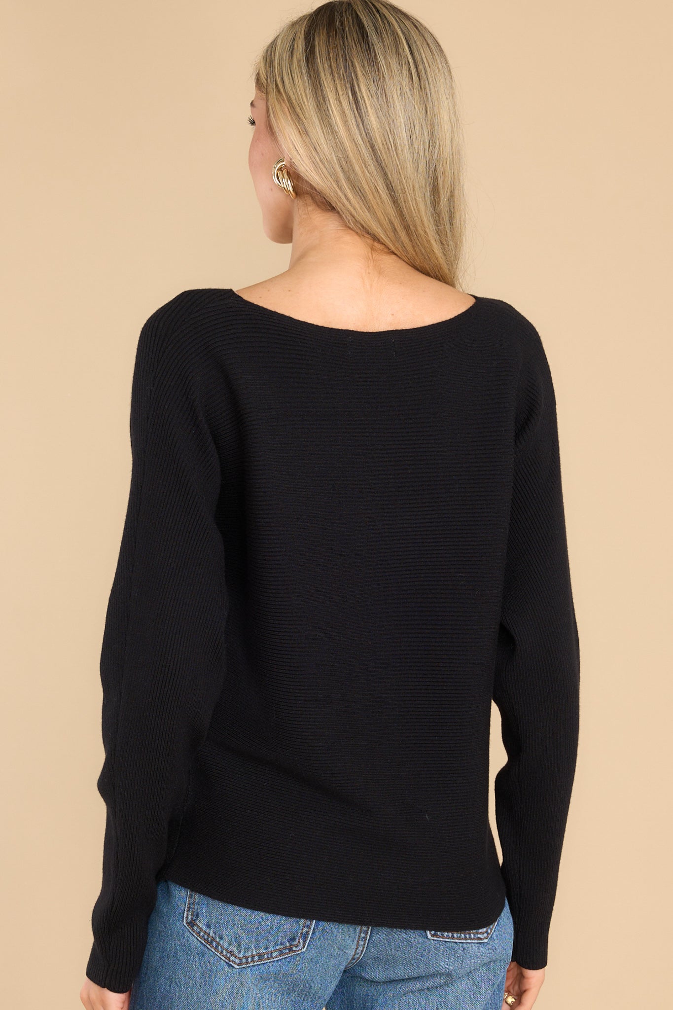 Back view of this sweater that features a round neckline and a soft stretchy material.