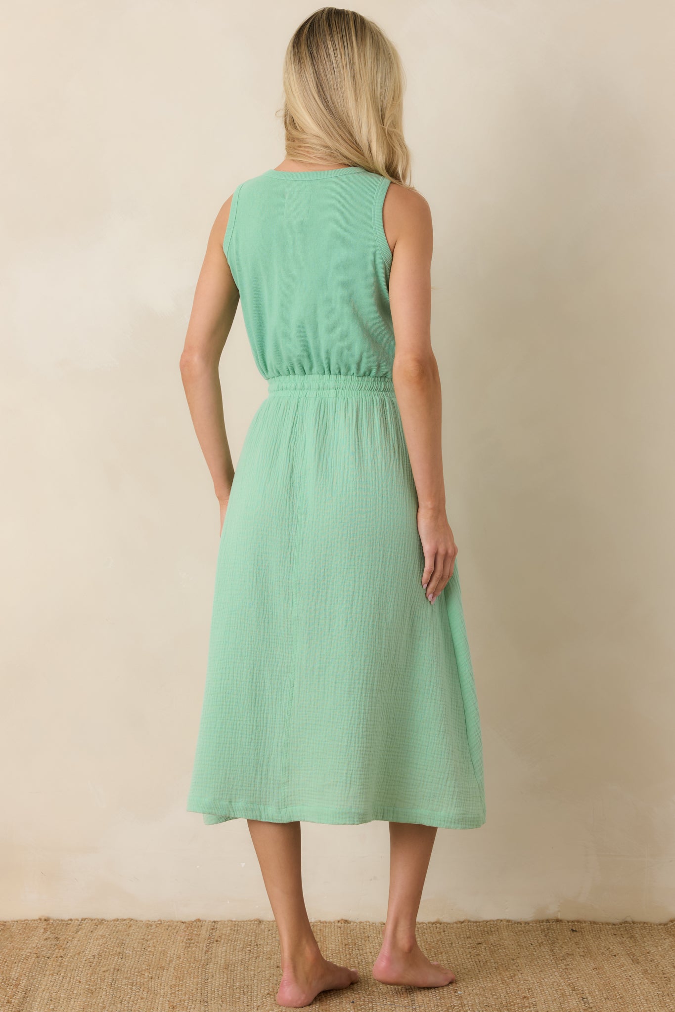 Rear view of the sleeveless midi dress with a relaxed fit and softly gathered waist.