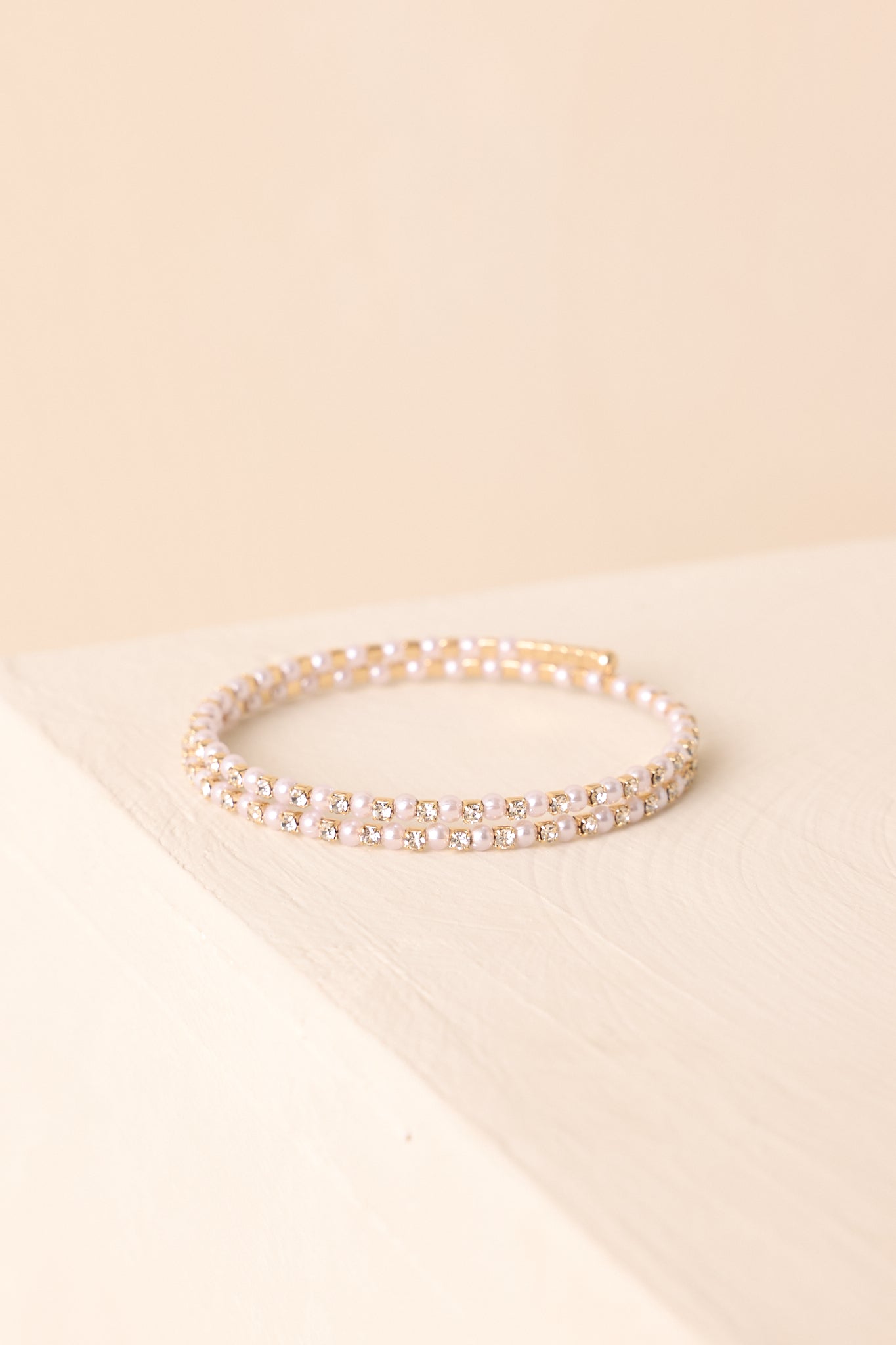 A close-up cropped shot highlighting pearl and rhinestone strands wrapped side by side in a flexible coil design.