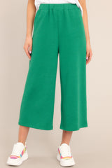 Front view of  these pants that feature a high waisted design, an elastic waistband, functional hip pockets, a textured crisscross design, and a wide leg.