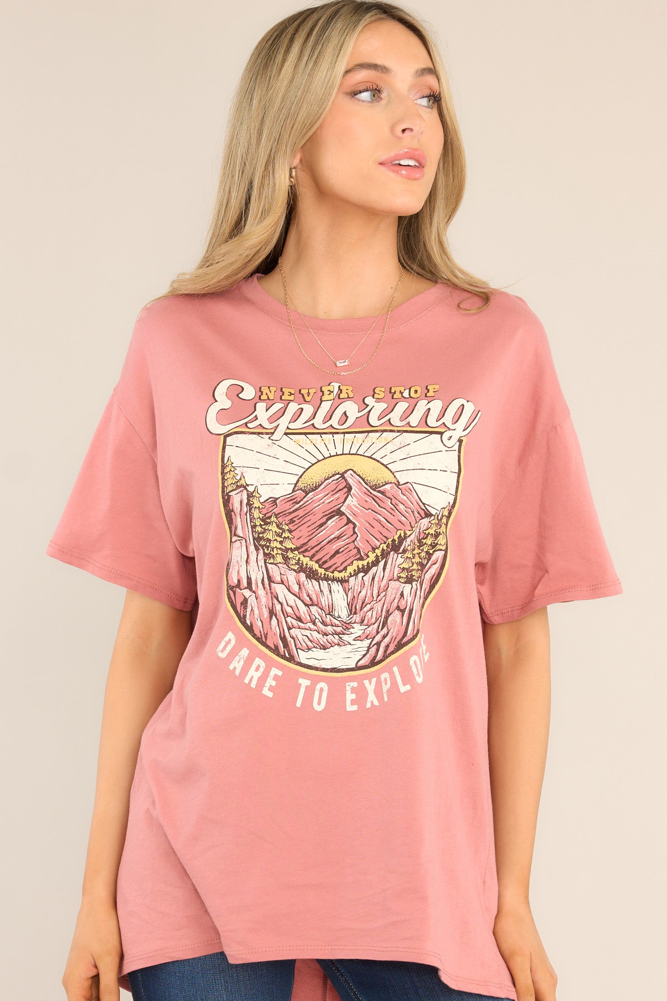 Front view of this top that features a crew neckline, dropped shoulders, a mountain graphic, and short sleeves.