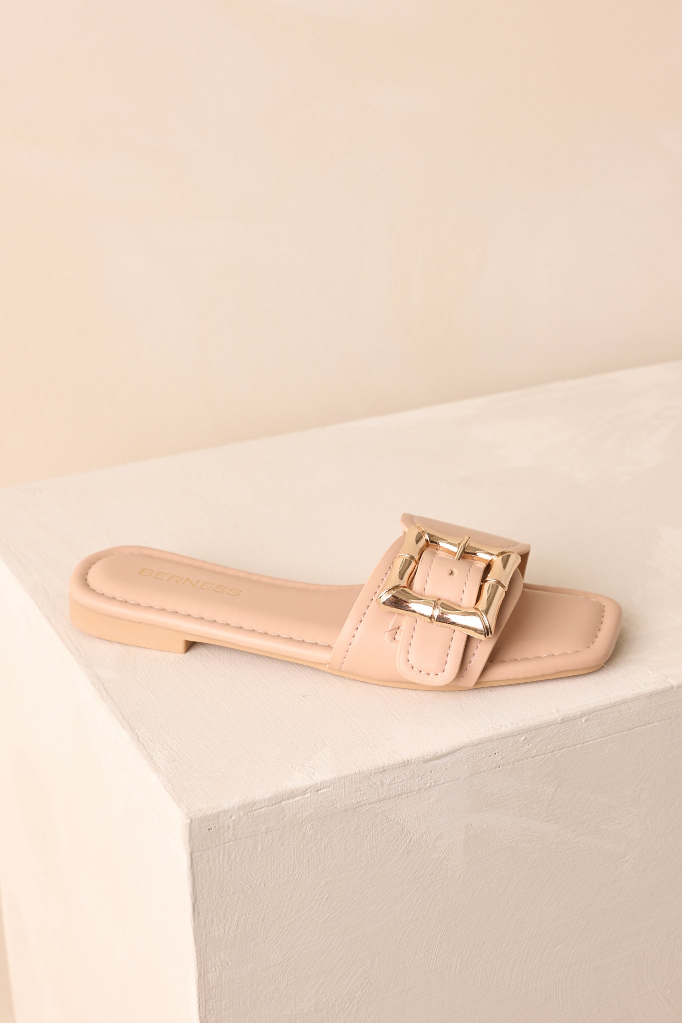 An overhead view of the beige slip-on sandal highlighting its smooth faux leather finish.