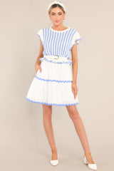 Full view of this dress that features a scalloped crew neckline, a striped knitted bodice, a ruffled waistline, functional pockets, scalloped detailing, a scalloped hemline, and ruffled sleeves.