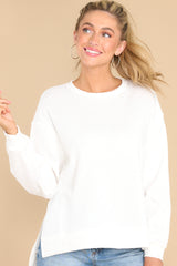 This off white sweater features a scoop neckline and two slits at sides.