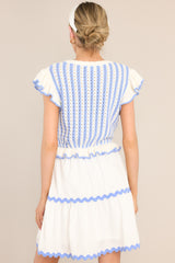 Back view of this dress that features a scalloped crew neckline, a striped knitted bodice, a ruffled waistline, functional pockets, scalloped detailing, a scalloped hemline, and ruffled sleeves.