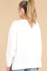Back view of this sweater that features a scoop neckline and two slits at sides.