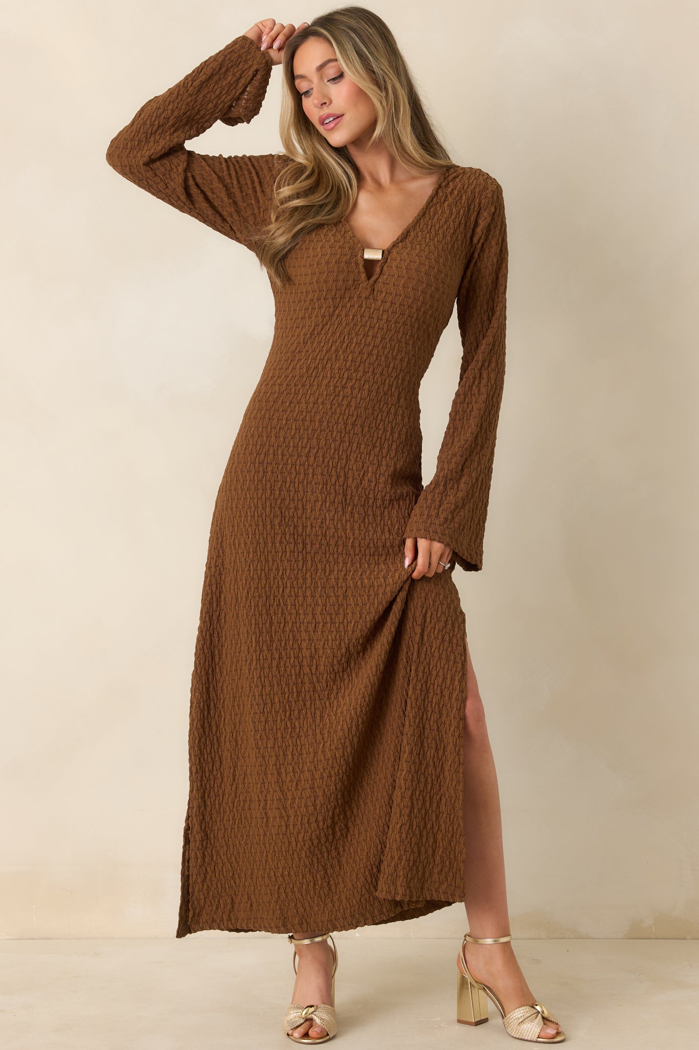 Brown textured maxi dress with graceful drape and long sleeves, displayed from a front angle.