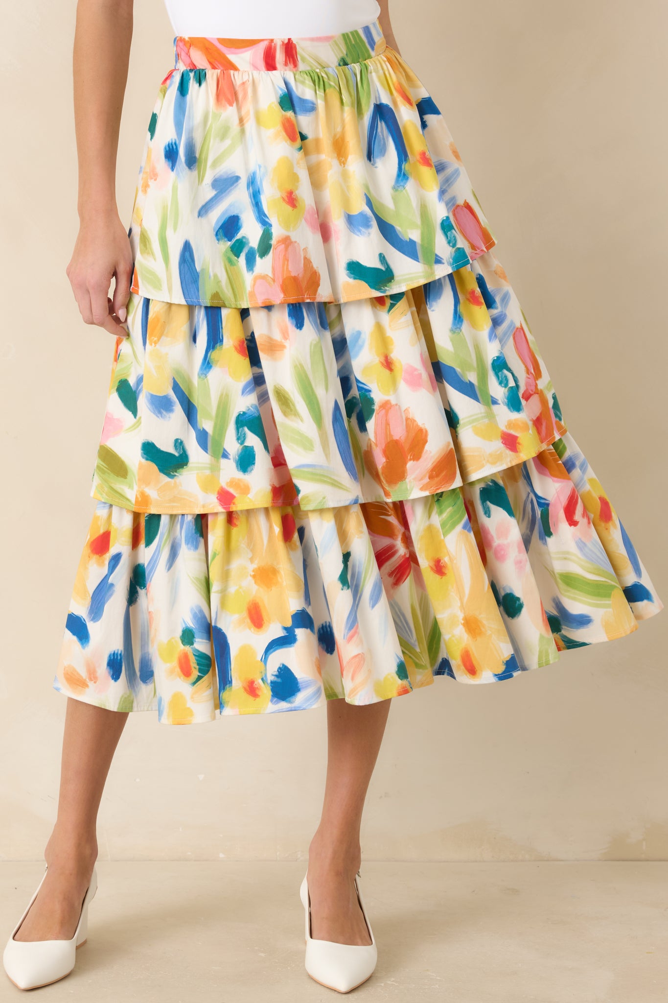 Multicolored cotton midi skirt with an abstract floral print, high-rise elastic waistband, and flowy tiered silhouette.