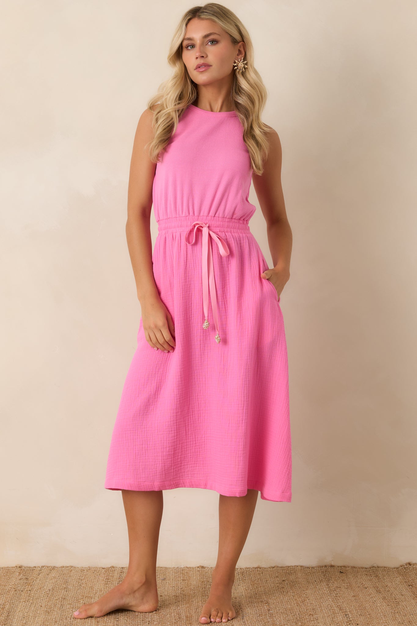 Relaxed fit midi dress with a sleeveless cut, adjustable drawstring waist, and easy drape.
