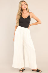 Full body view of these pants that feature an elastic waistband and a flowy wide leg.