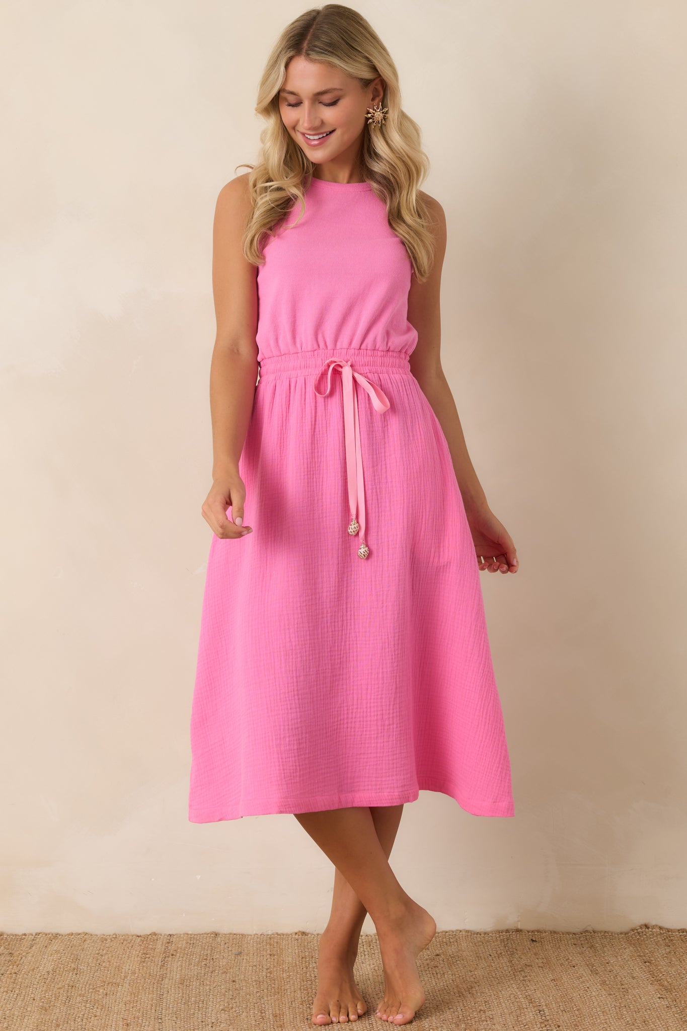 Sleeveless midi dress with a round neckline and adjustable drawstring waist creating a softly defined silhouette.
