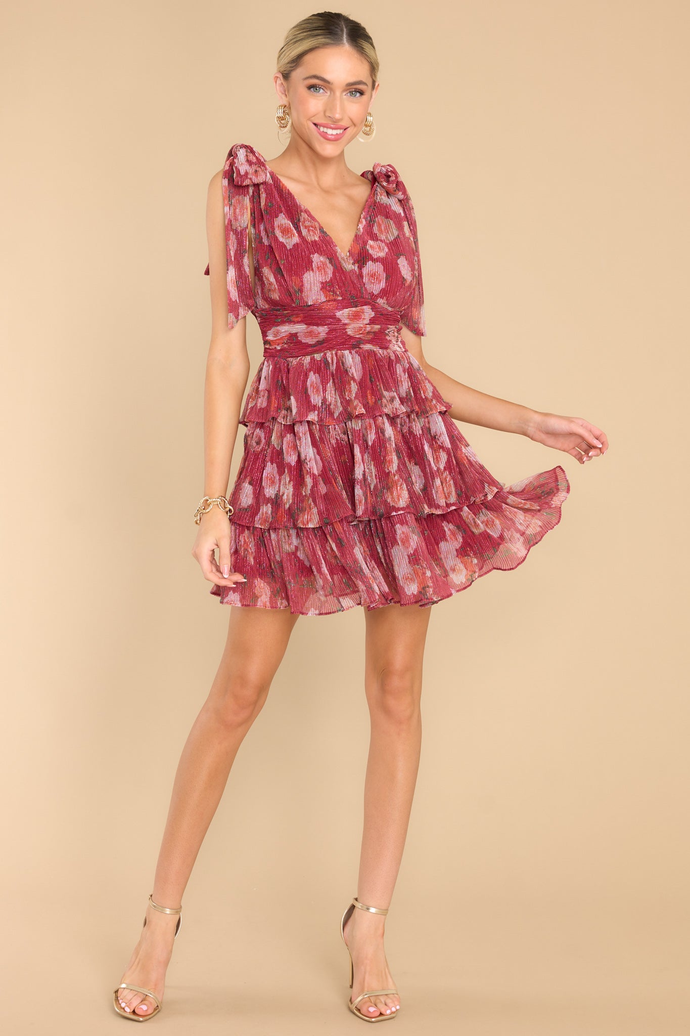 Full body view of burgundy dress featuring a deep v-neckline, and bow details on the straps.