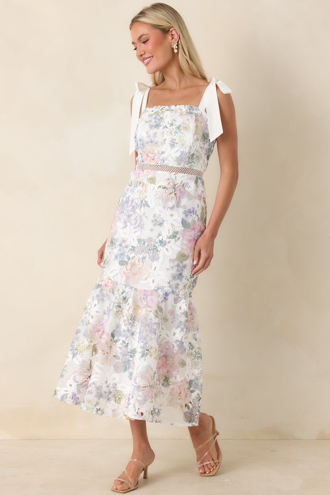 Slightly turned front view emphasizing the self-tie straps and lace knitted overlay on the midi dress.