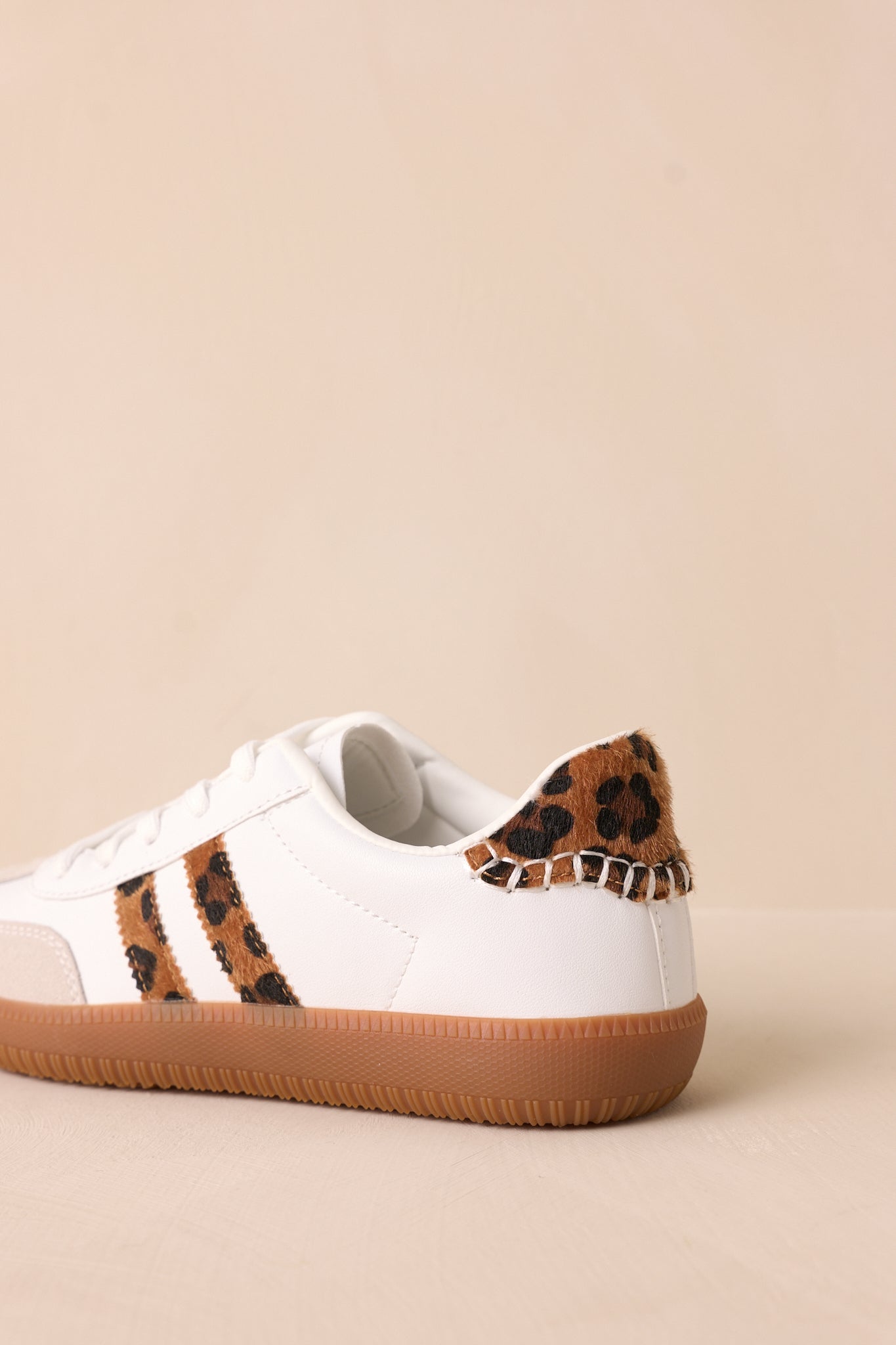 The back view of the sneakers reveals the leopard faux fur at the ankle and the clean brown sole, adding a unique touch to the classic white sneaker design.