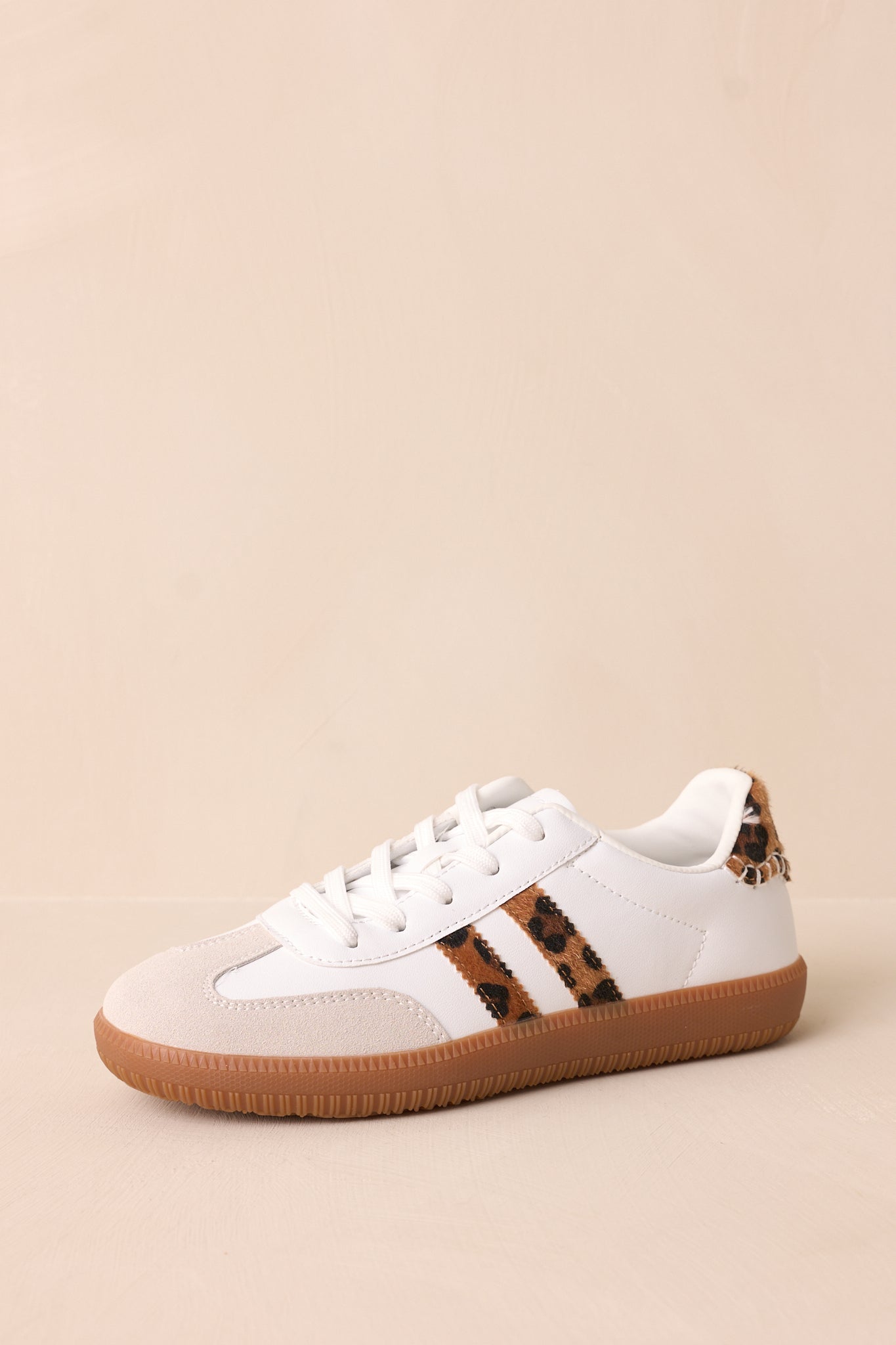 A different angle highlighting the white faux leather material, brown sole, and the trendy leopard faux fur section at the ankle of the sneakers.