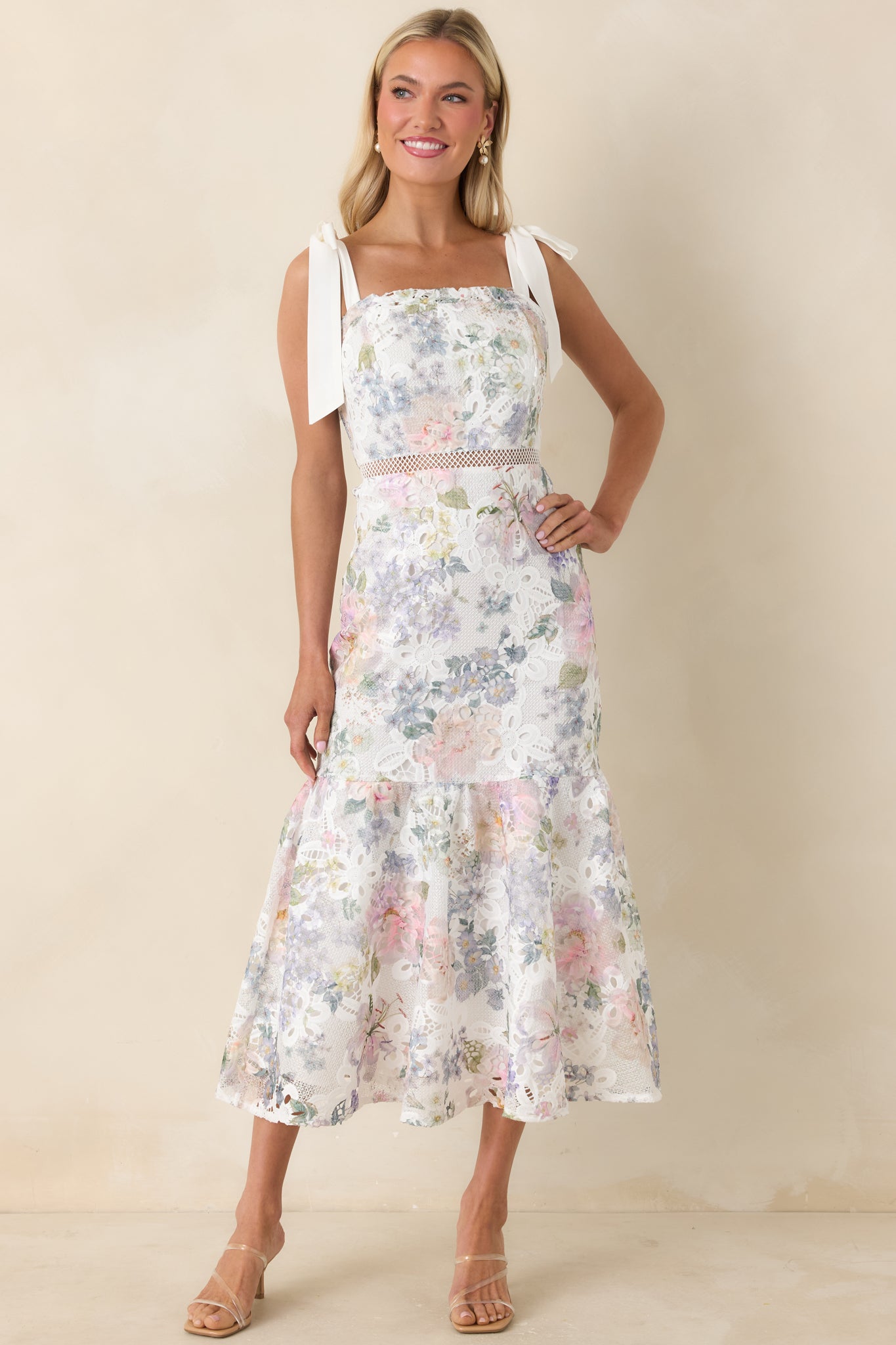 Slightly angled front view of the lace midi dress with self-tie shoulder straps and flowing tiered design.