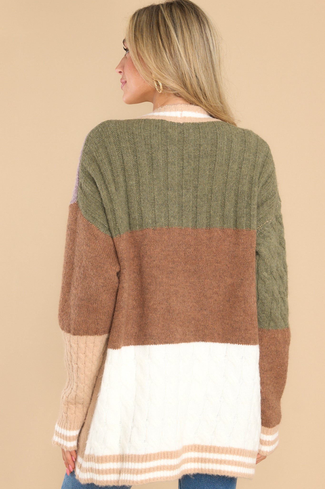 Back view of this cardigan that features a v-neckline, functional buttons down the front, stripe detailing along the hem and cuffs, cable knit detailing, and a soft, knit material throughout.