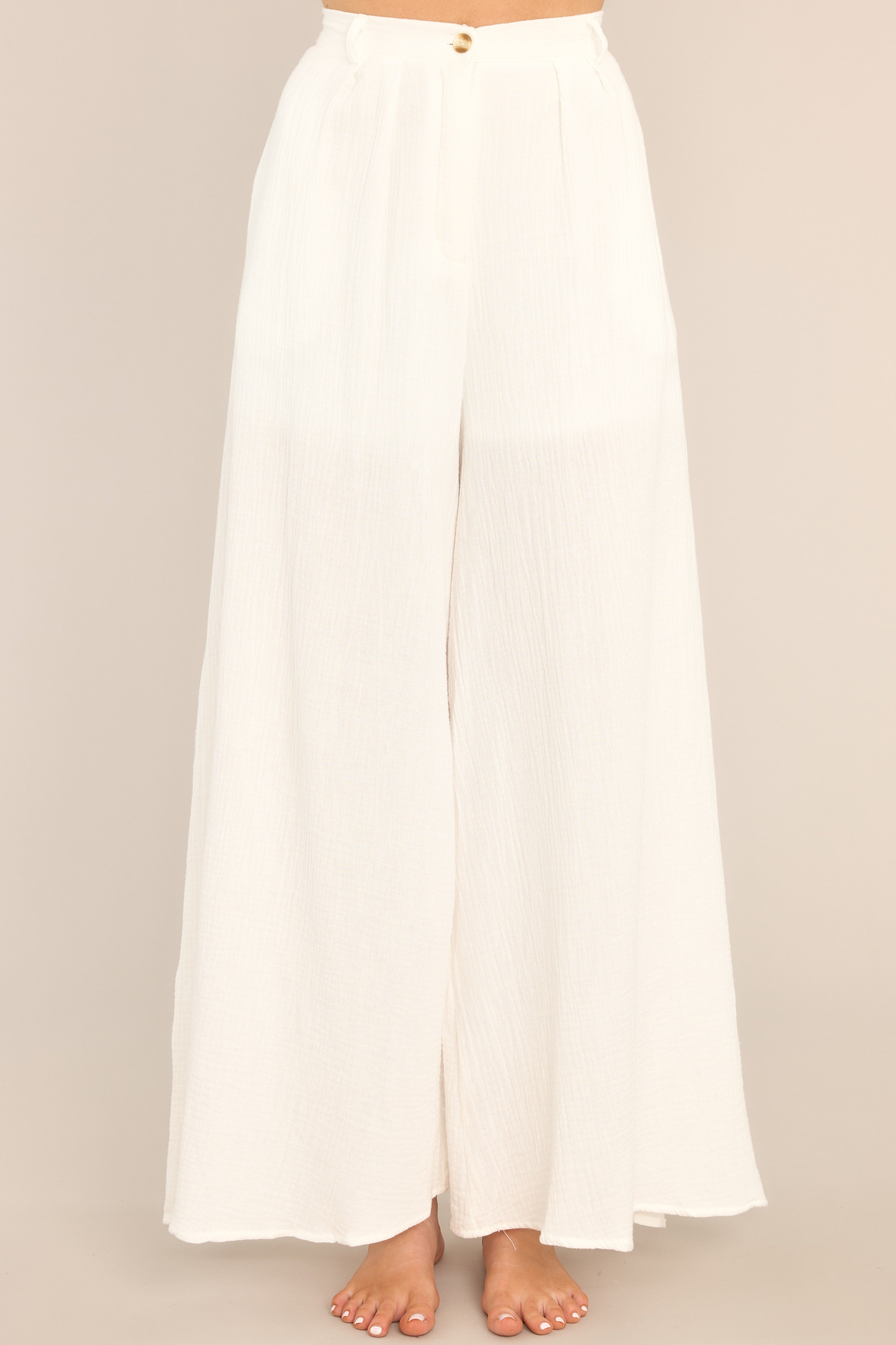 Full view of these pants that feature a high-rise design, an elastic band at the back of the waist, a zipper and button closure, belt loops, functional side pockets, and a lining that extends from the waist to the upper thigh.