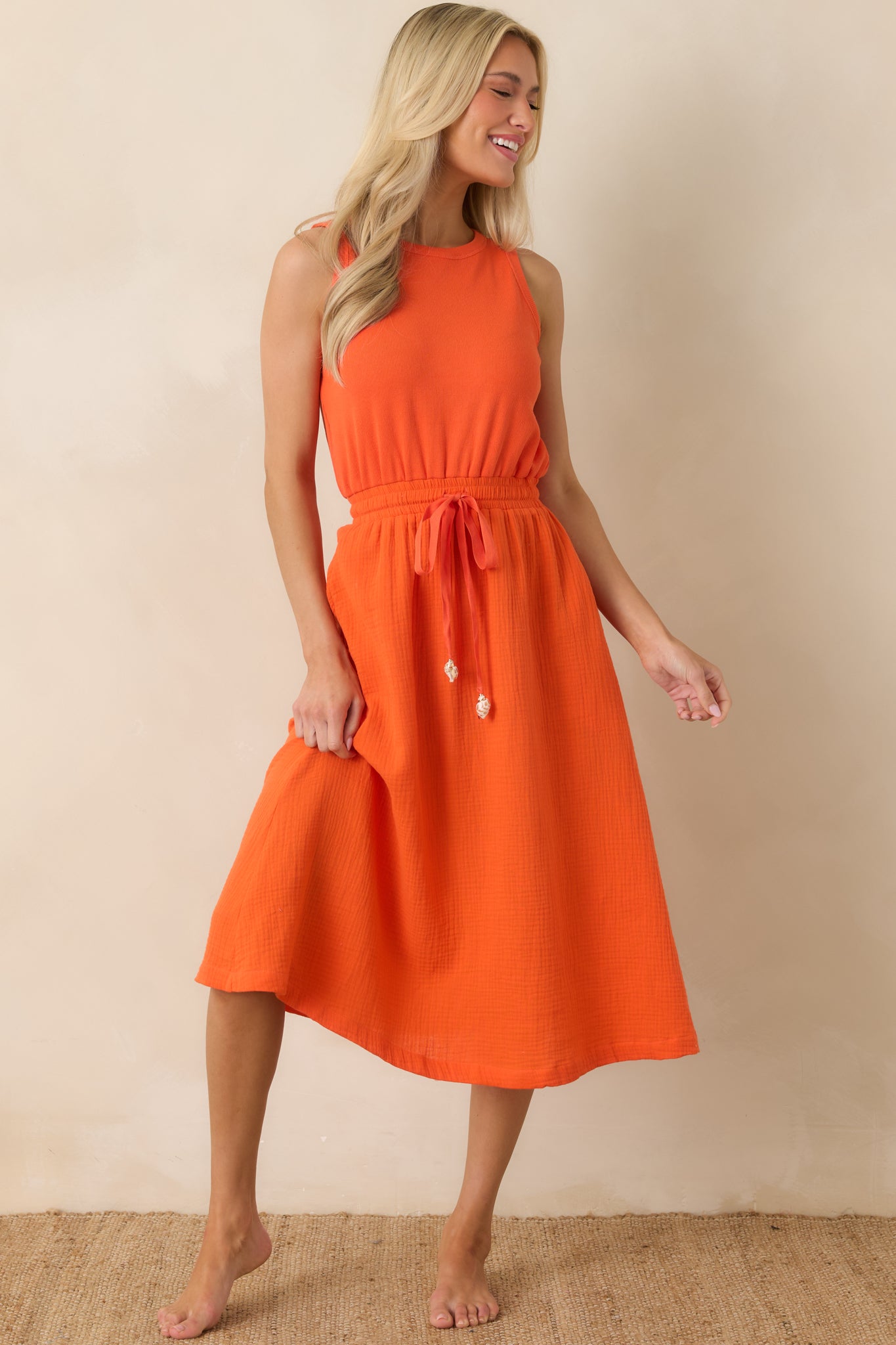 Breathable midi dress with a sleeveless cut, adjustable drawstring waist, and fluid silhouette.