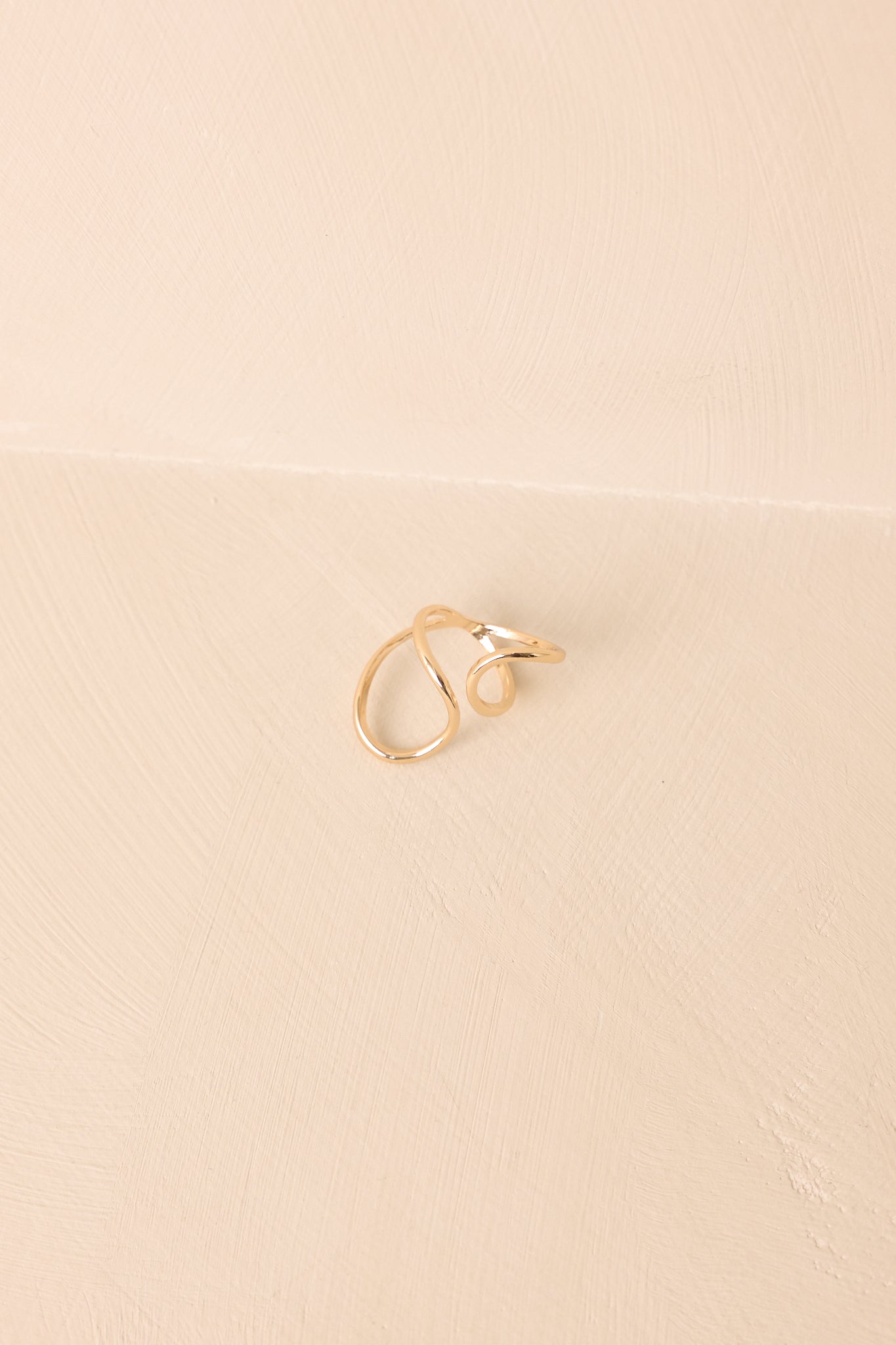 Cropped photo highlighting the open-ended gold ring with two smooth, curved bands.