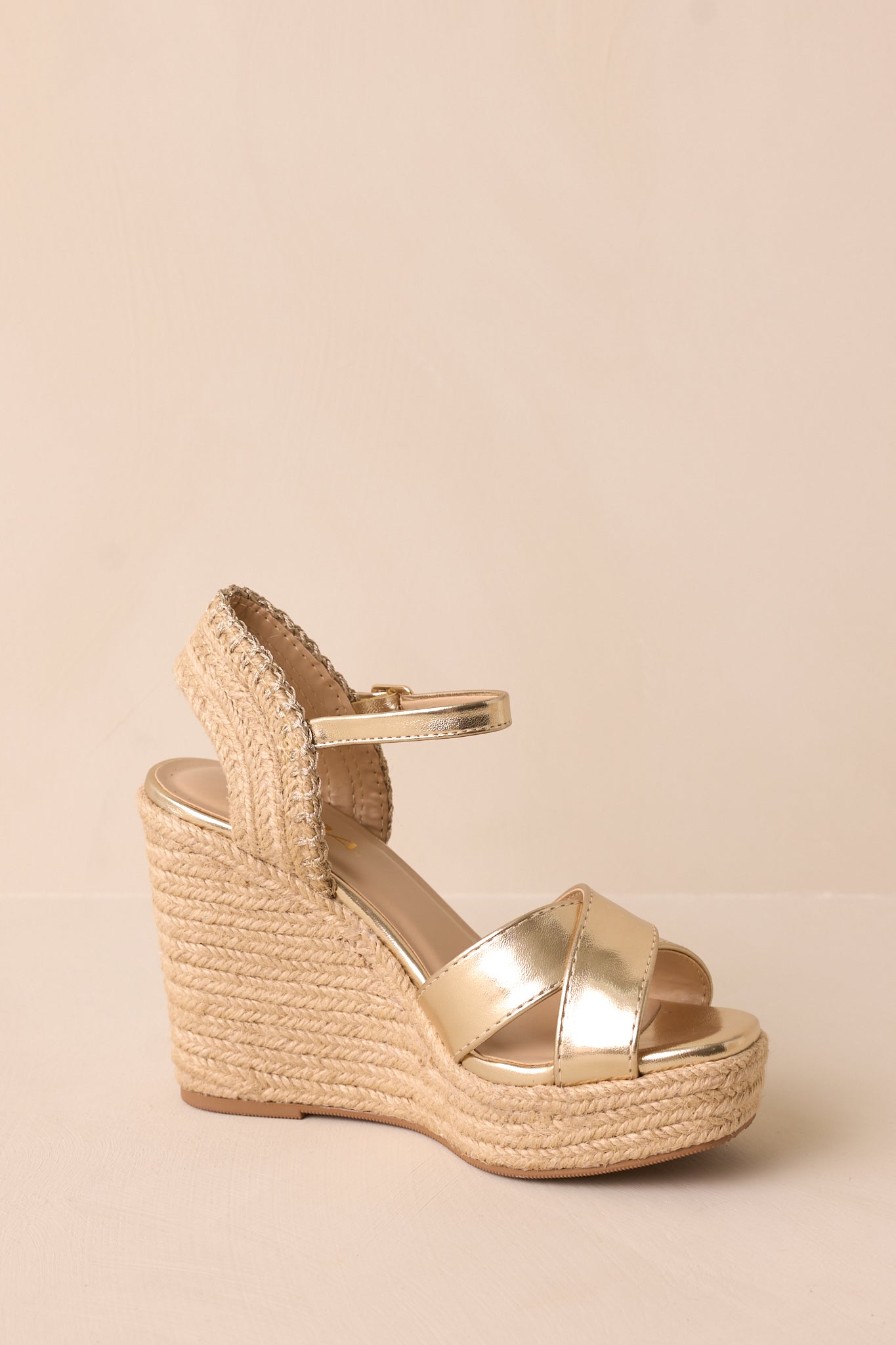 A side angle showing the sandals with the focus on the wedged heel, platform bottom, and the adjustable strap around the ankle.