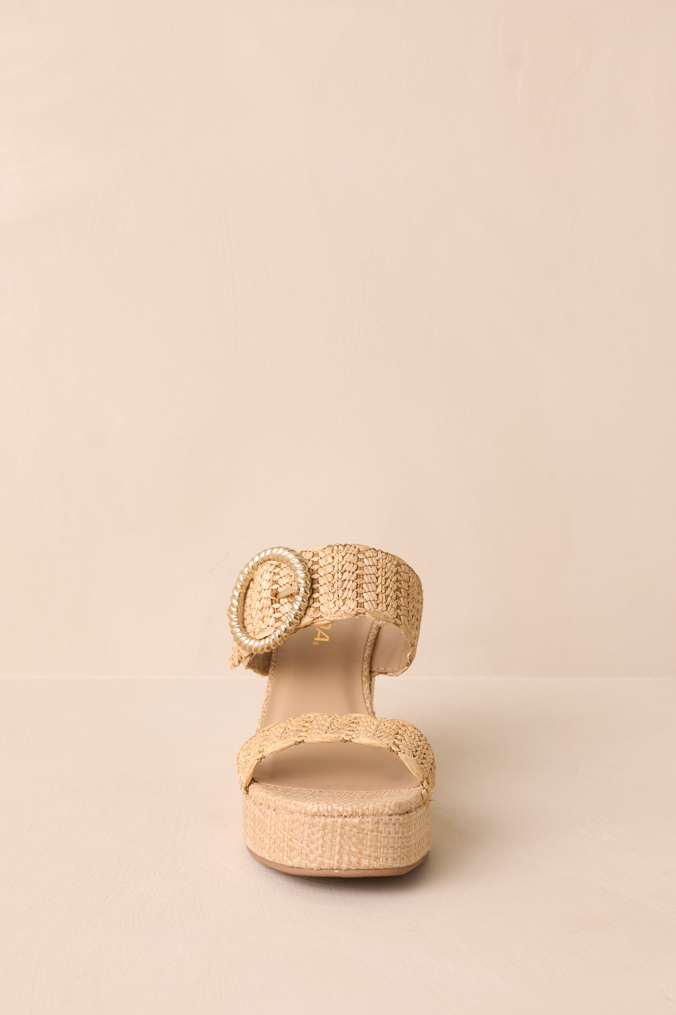 A front-facing view of the wedges, emphasizing the rounded toe, double strap design, and slip-on structure.