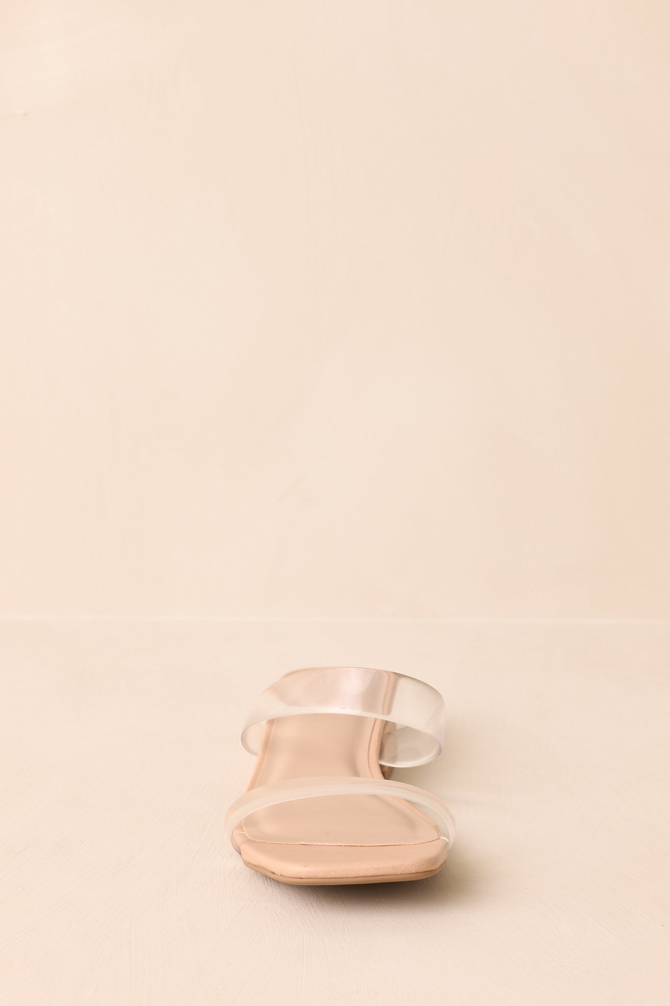 Front-facing view of clear strap heels highlighting open-toe and square sole.