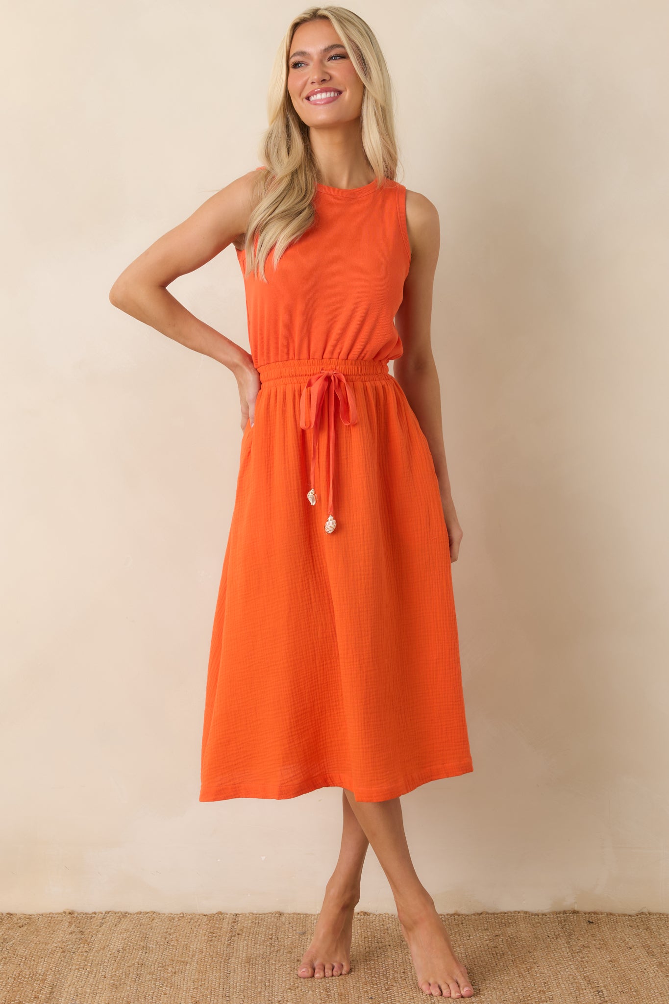 Soft, lightweight midi dress featuring a sleeveless silhouette, round neckline, and flowing skirt.