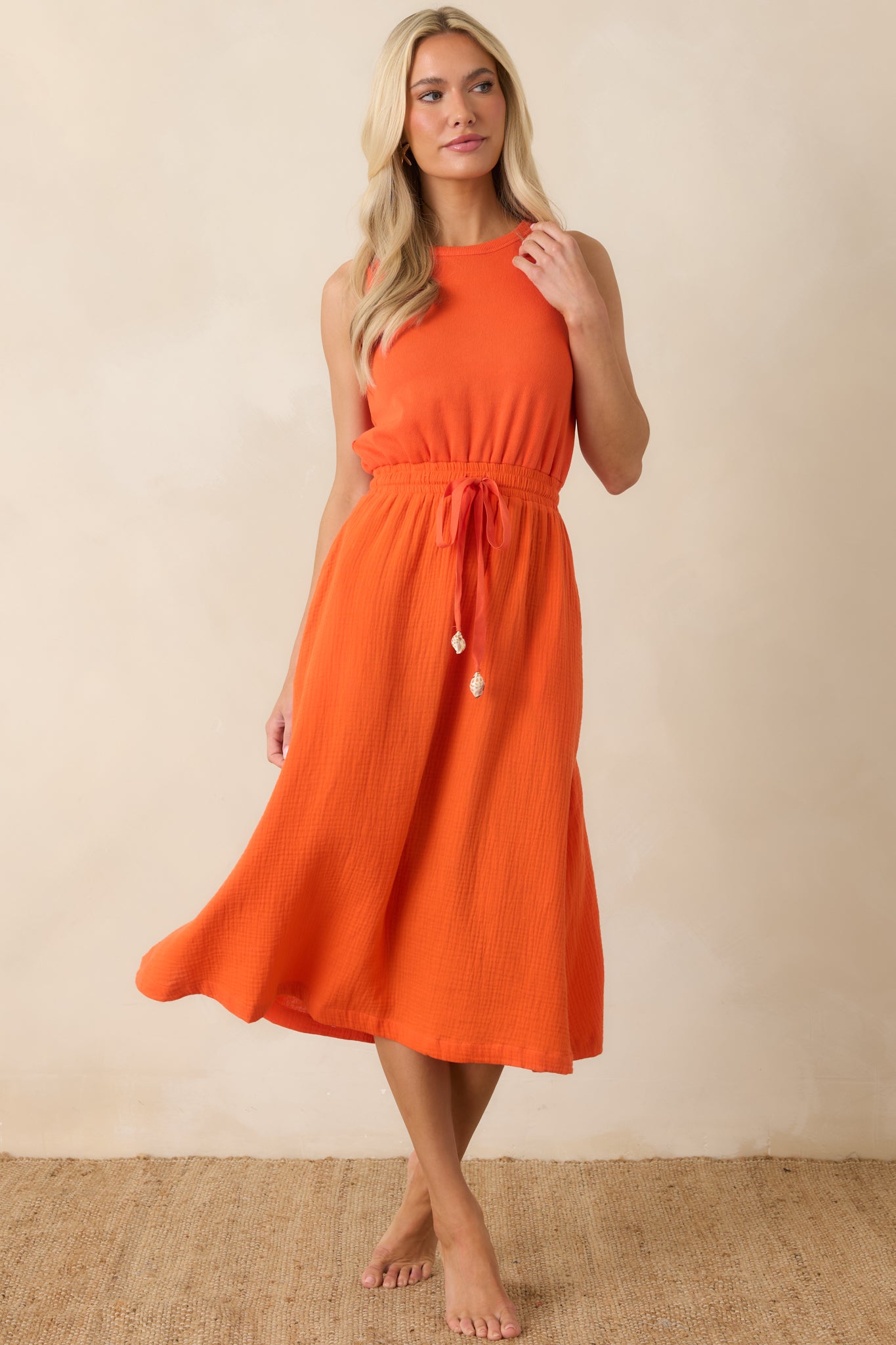 Sleeveless midi dress with an elasticized waist and adjustable drawstring for a flattering fit.