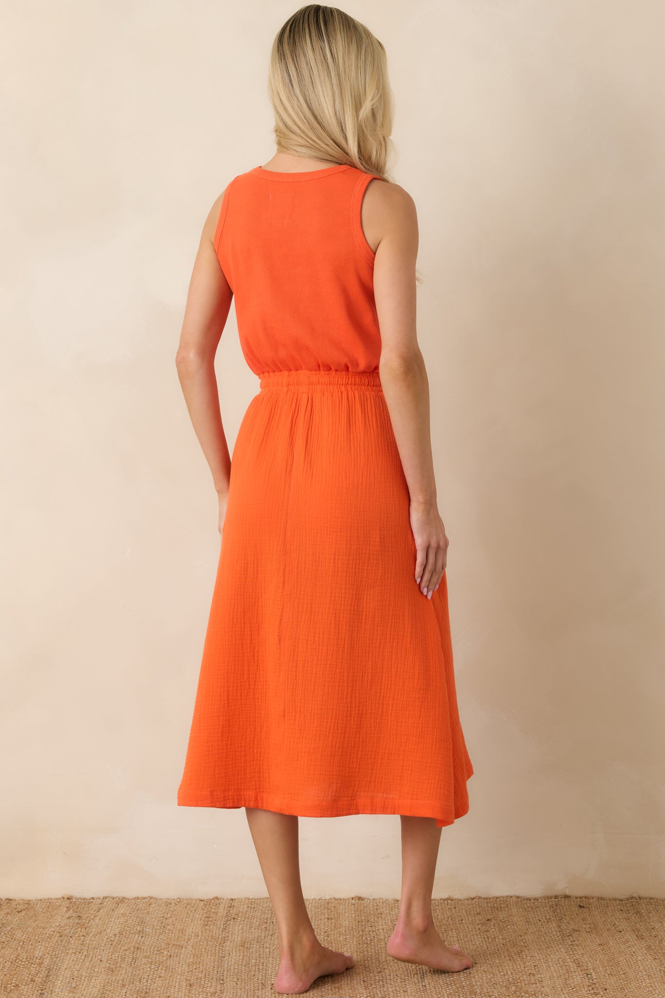 Rear view of the sleeveless midi dress featuring a relaxed silhouette and softly gathered waist.