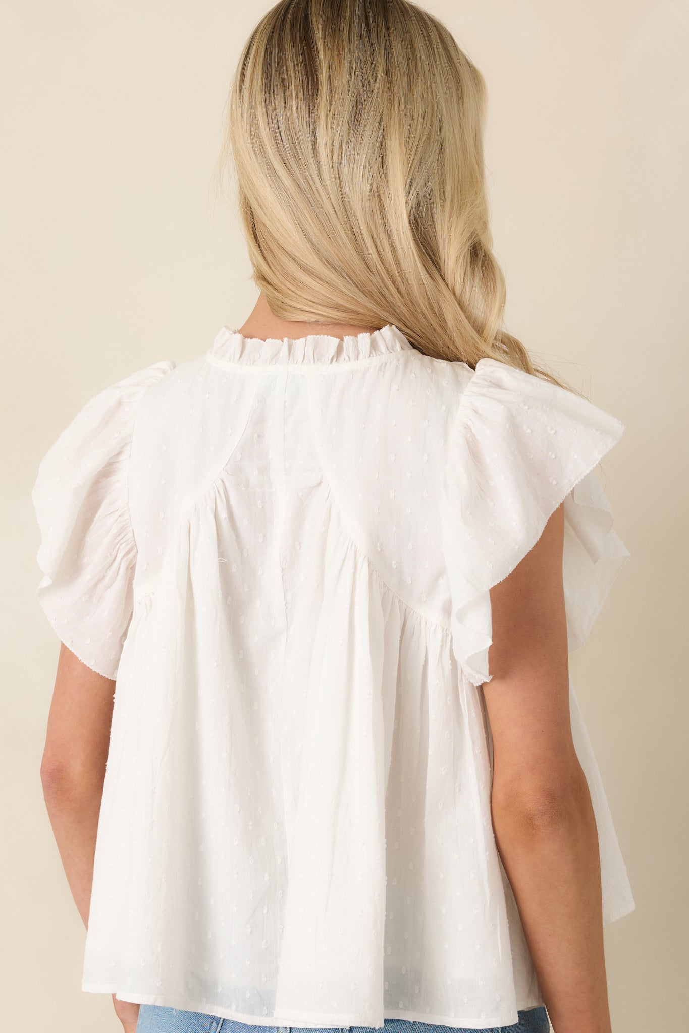 Rear view of cotton blouse showing relaxed drape and continuous lace detailing.