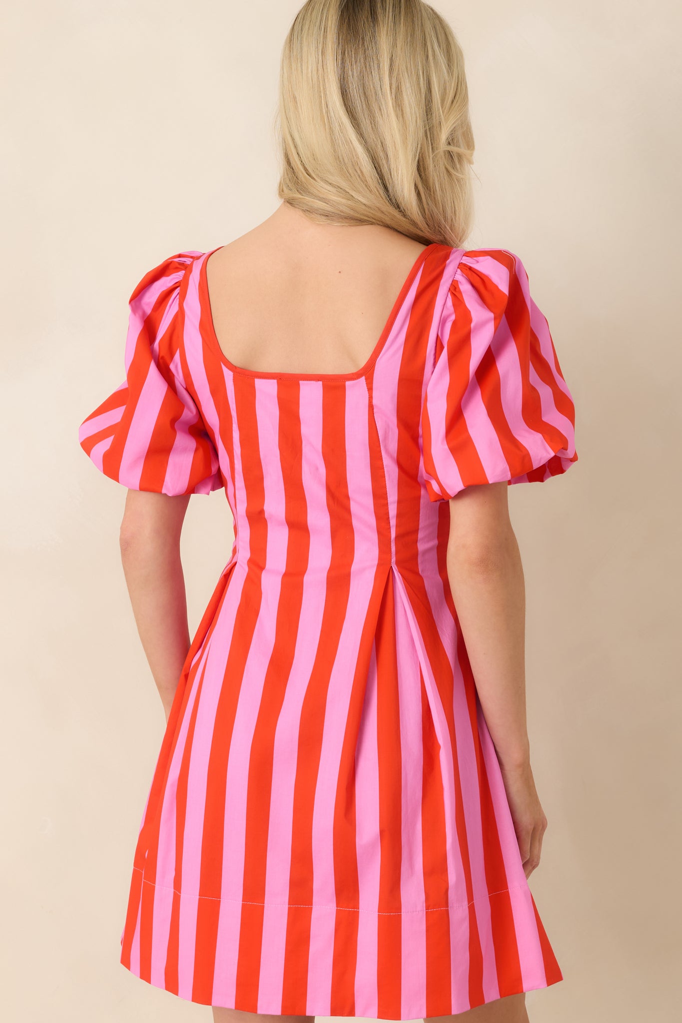 Rear view of cotton mini dress featuring concealed side zipper closure and softly flared skirt.