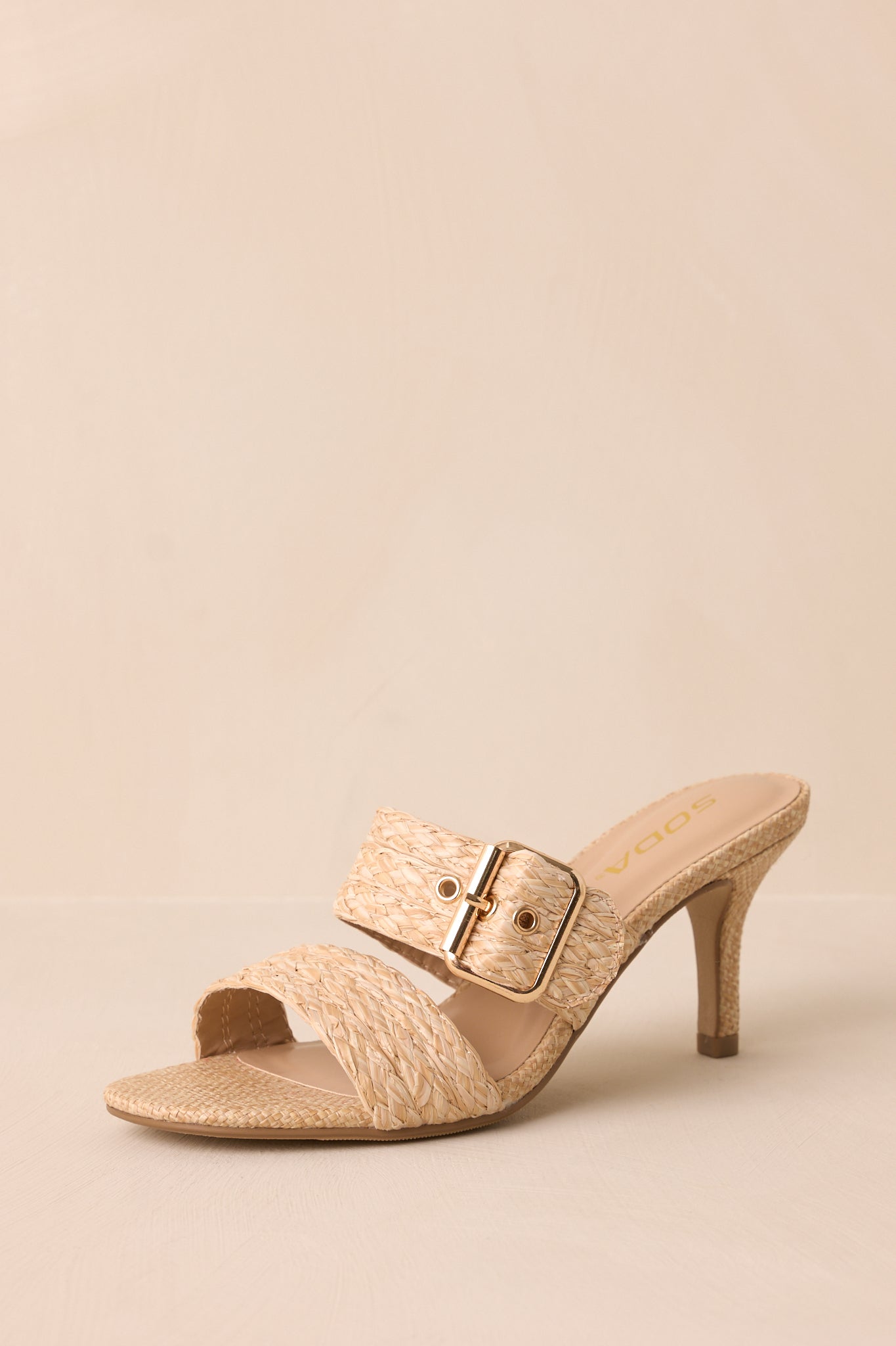 A slightly angled perspective showing the balance between the straps, gold buckle, and the structured heel.