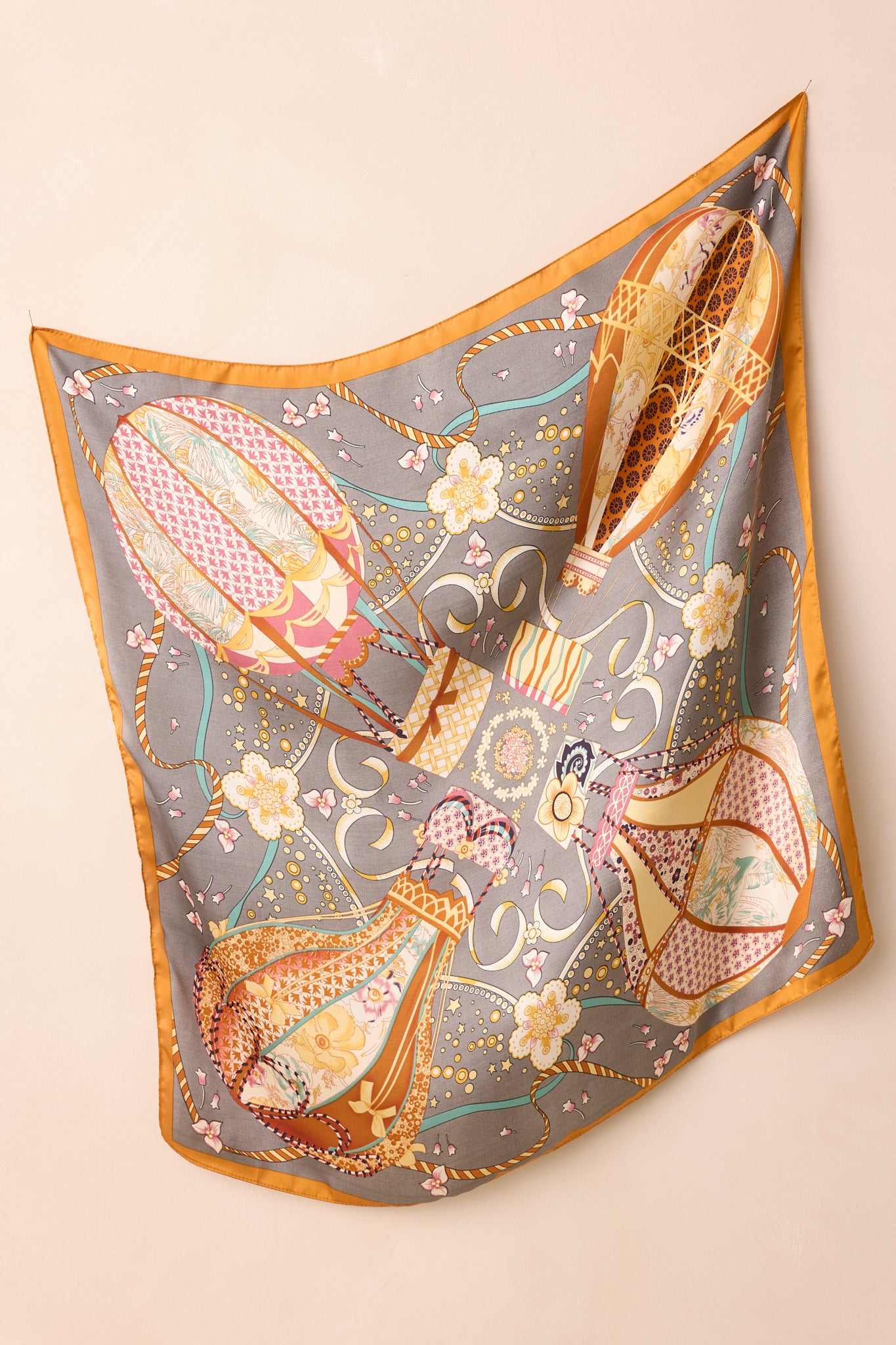 A full view of the slate grey satin scarf featuring a multicolored hot air balloon print.