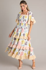 Front view of this dress that features a square neckline, butterfly sleeves, a fully smocked bust, and a long, flowy skirt.