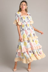 Full body view of this dress that features a square neckline, butterfly sleeves, a fully smocked bust, and a long, flowy skirt.