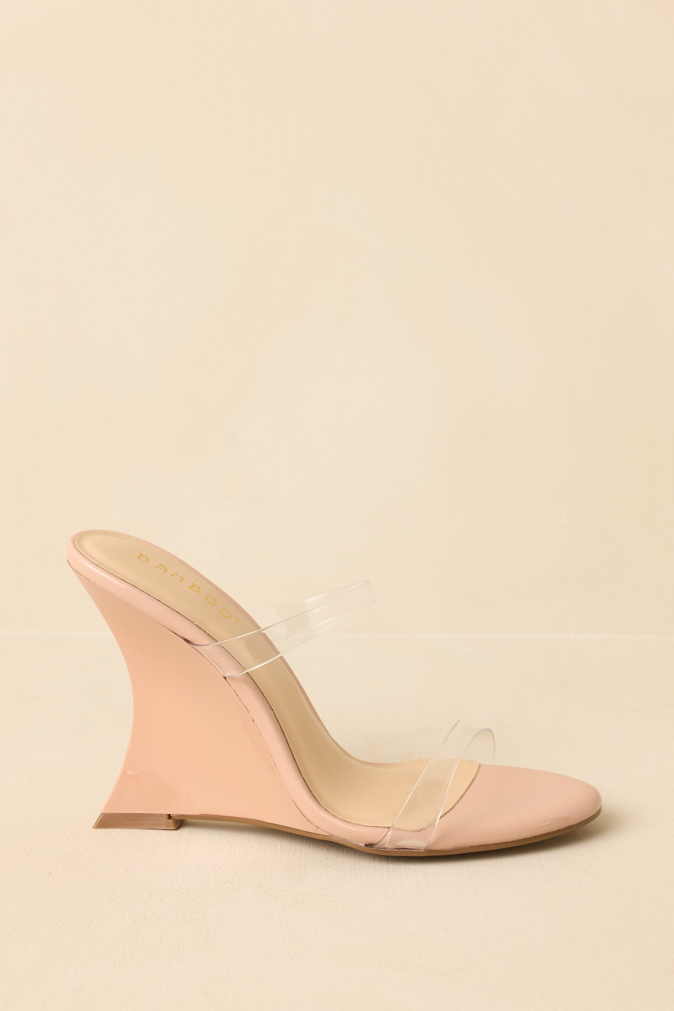Beige wedge heels displayed from the side to show the full wedge height and modern profile.