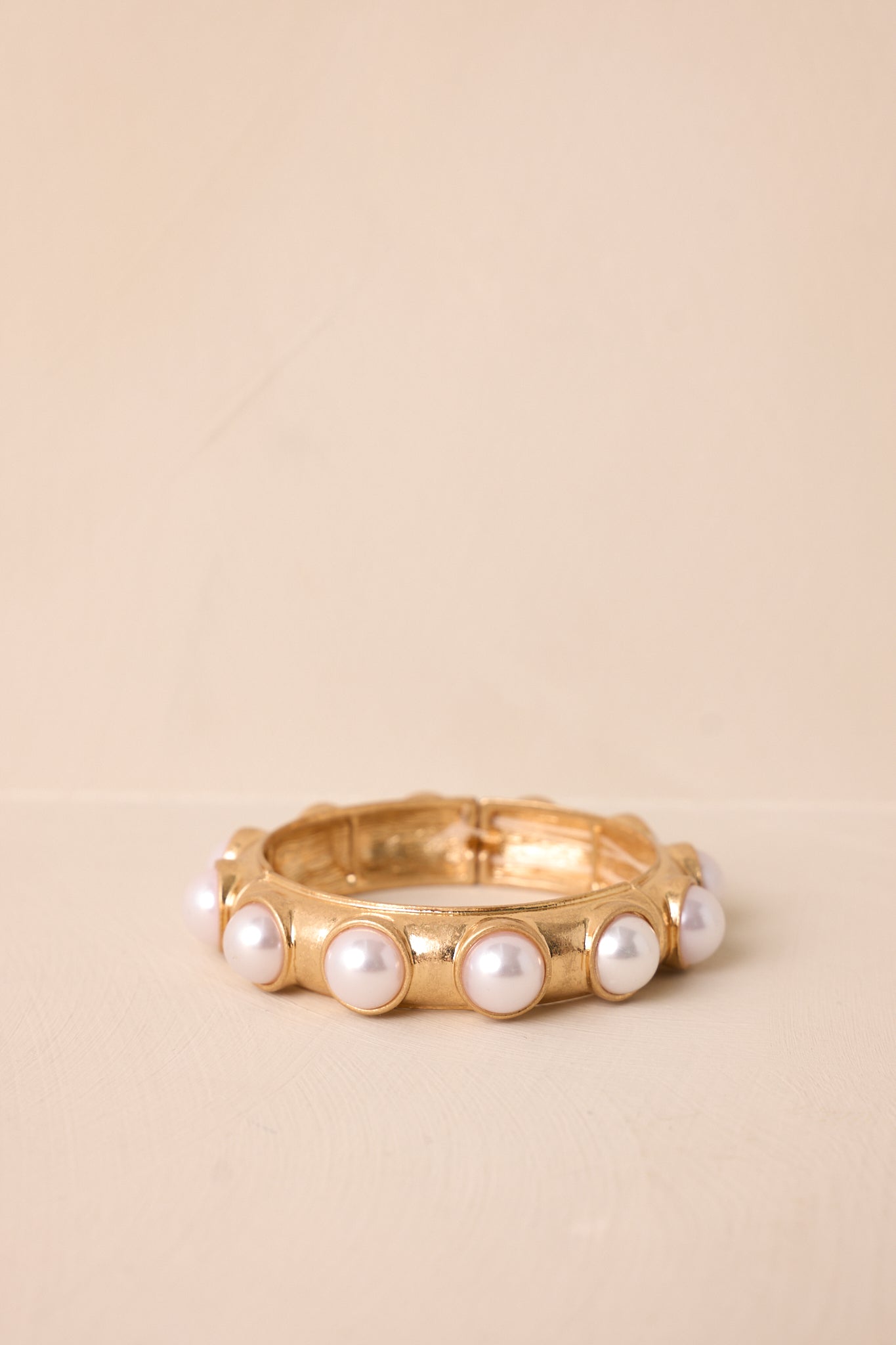 A detailed side angle capturing the beaded faux pearls and the elegant gold accents.