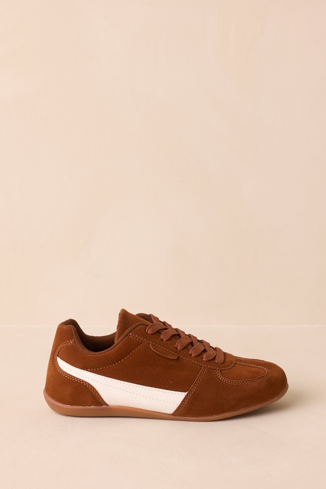 Side profile highlighting the brown faux suede material and cushioned flexible sole.