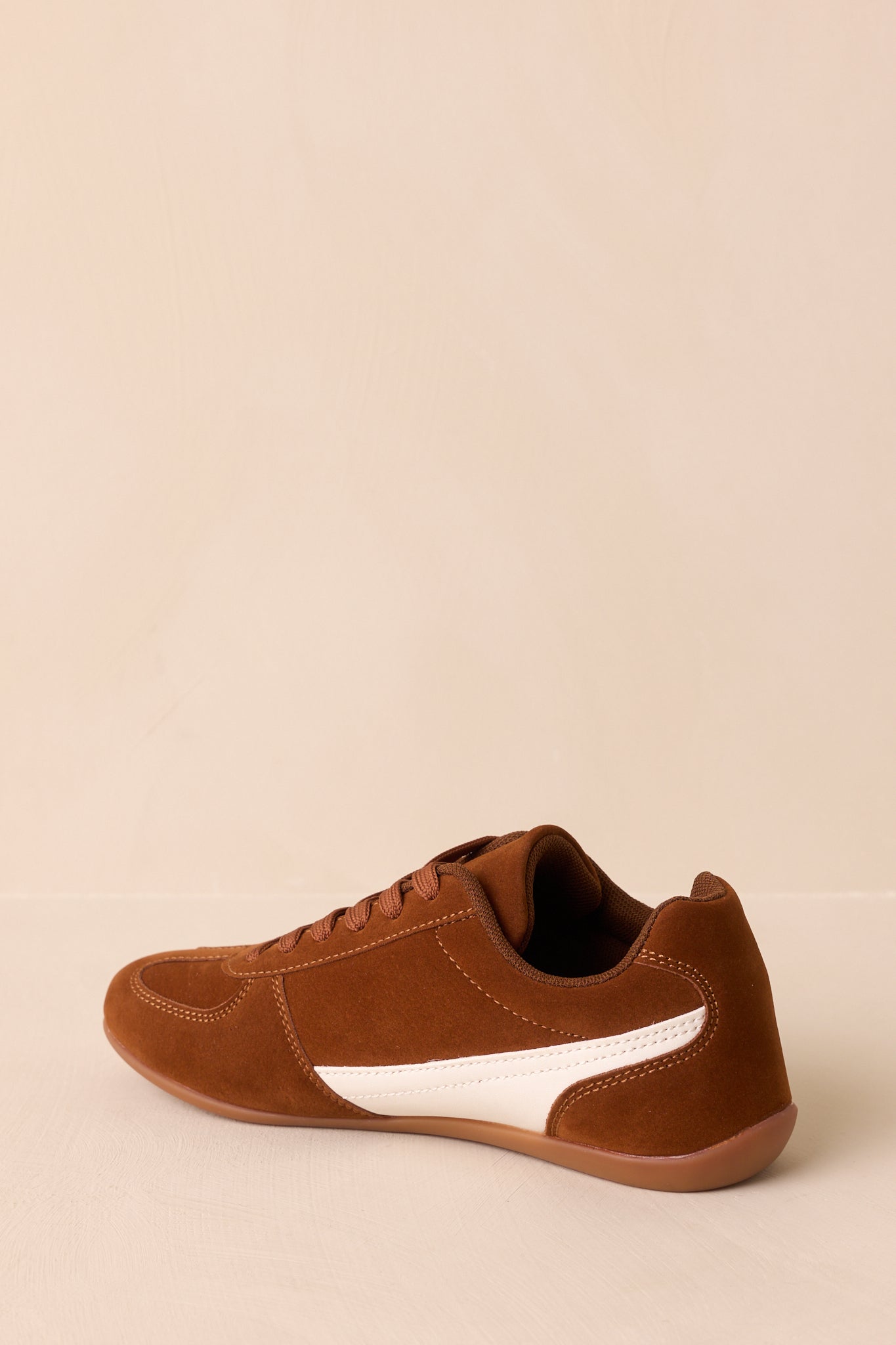 A back view of the sneakers, showing the heel panel with white faux leather detail and a flexible sole.