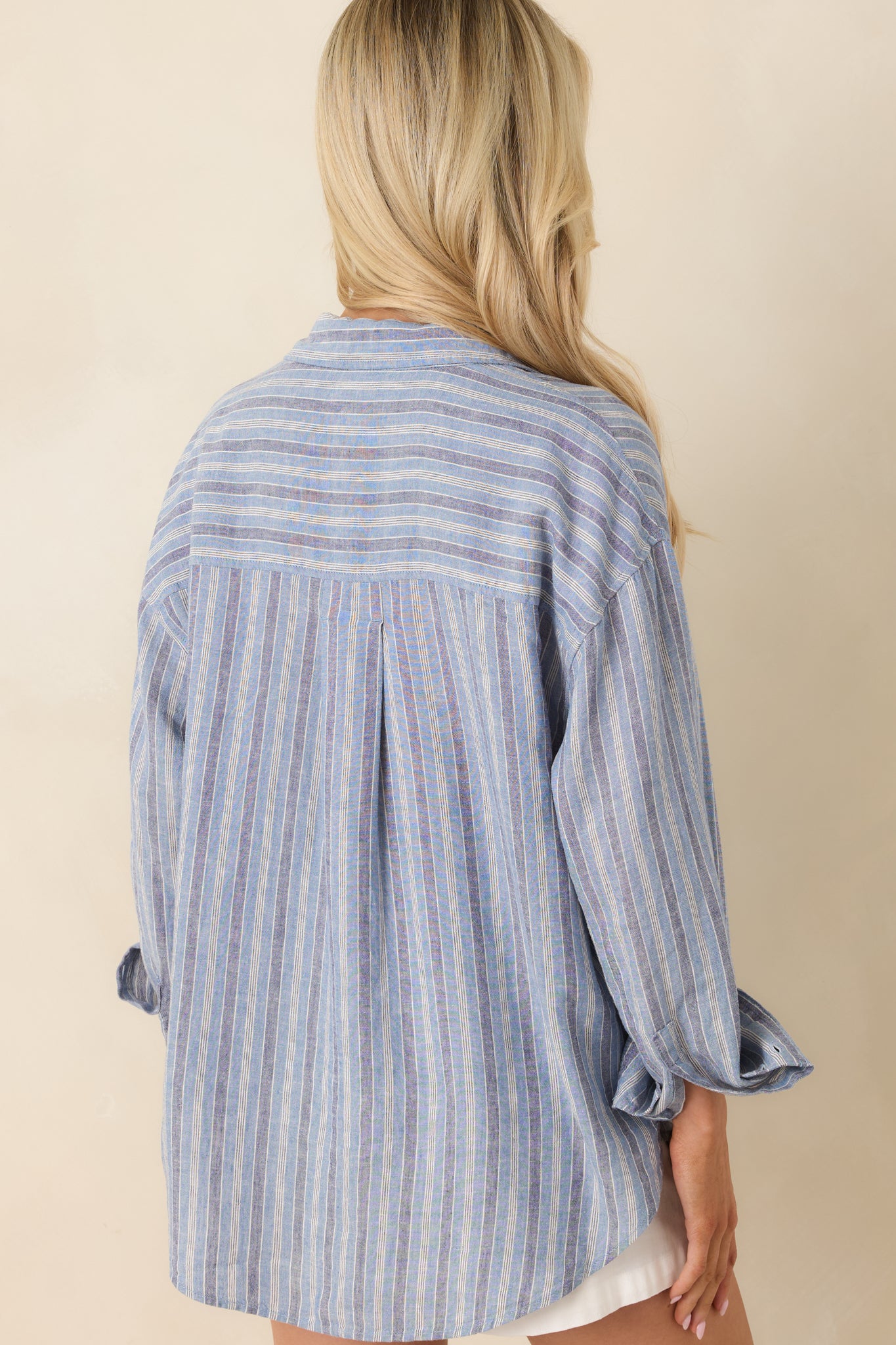Indigo striped top with relaxed rear silhouette and long sleeve structure.