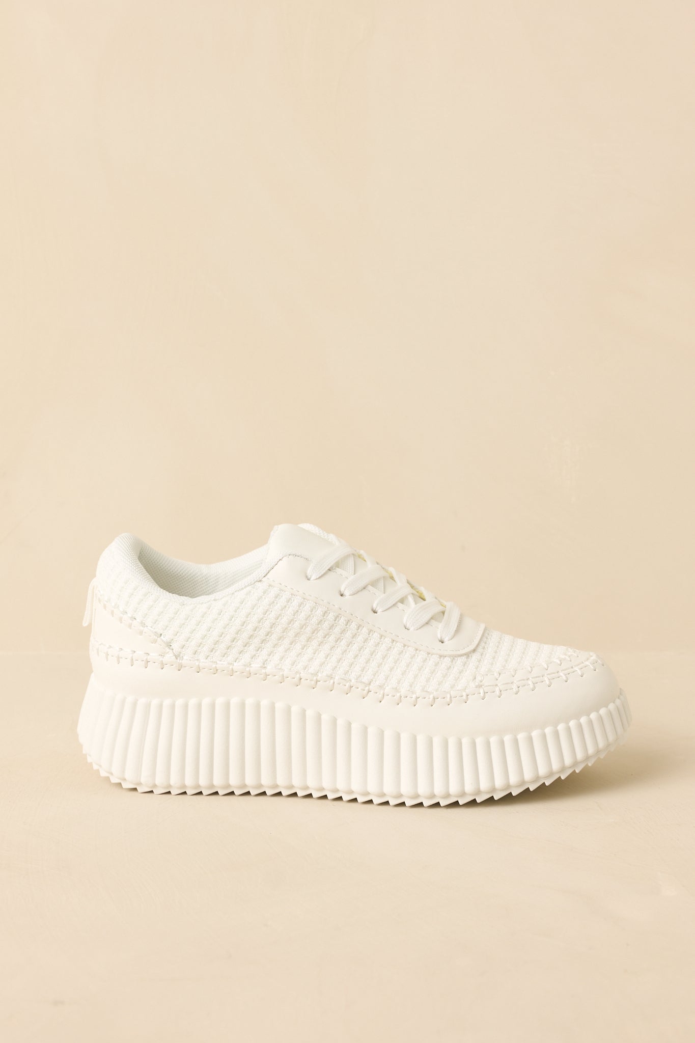 White sneakers angled to highlight the cushioned interior and elevated platform sole.