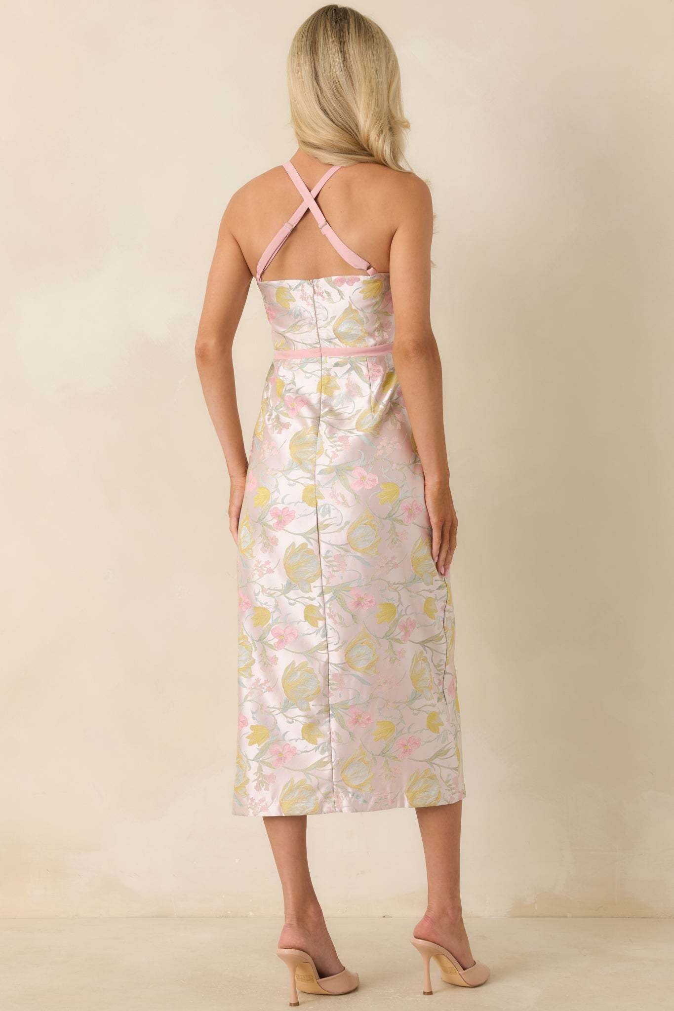 Pink shimmer floral midi dress from the back, featuring adjustable spaghetti straps in a crisscross design and a concealed zipper closure for a smooth finish.