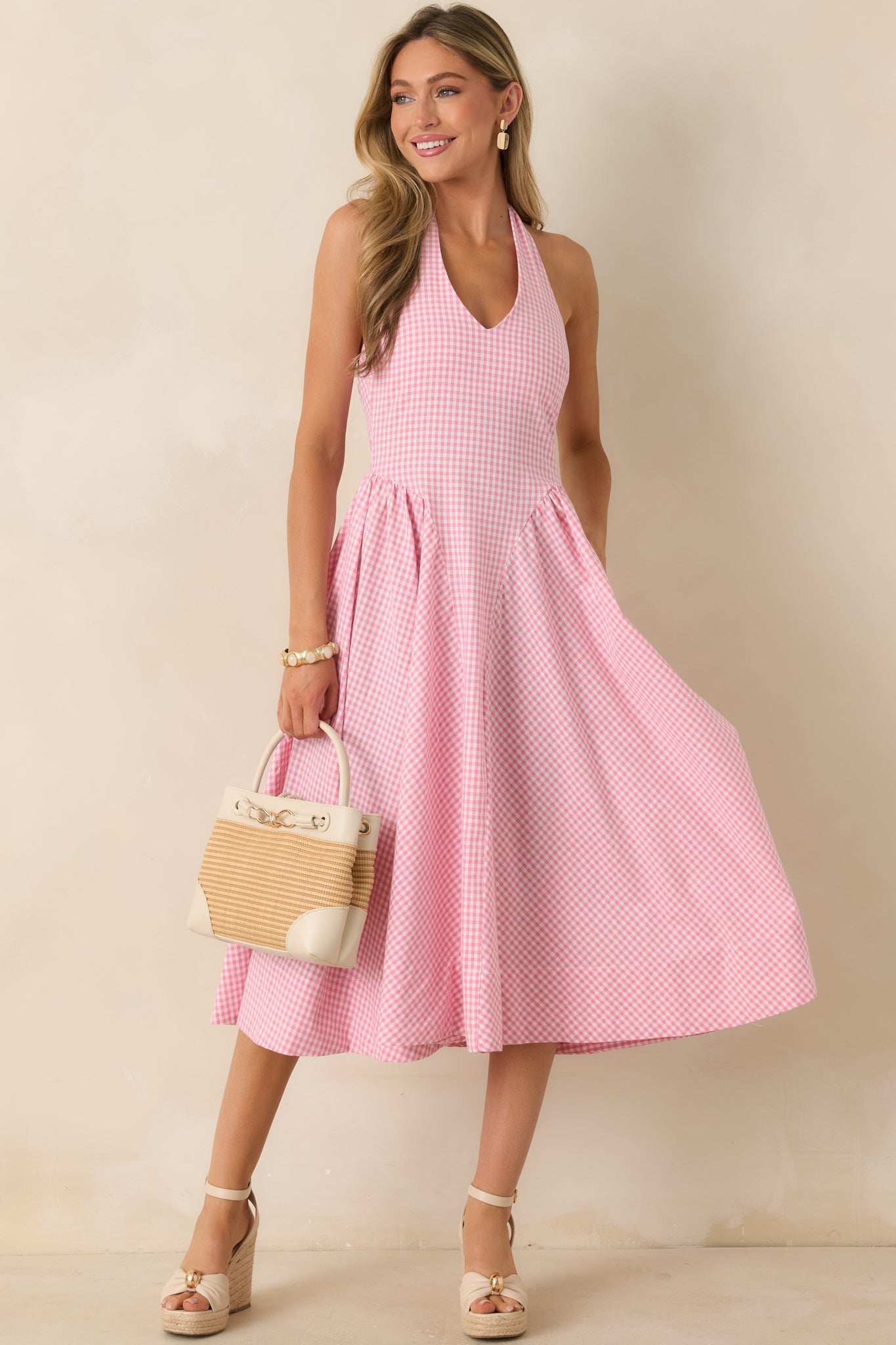 Gingham midi dress showcasing a flattering silhouette with a halter top and softly flared midi-length skirt.