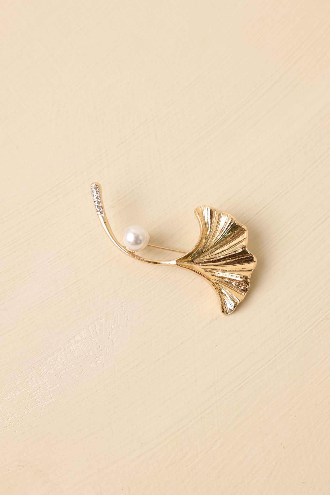 Gold ginkgo brooch with an accent pearl on the stem.