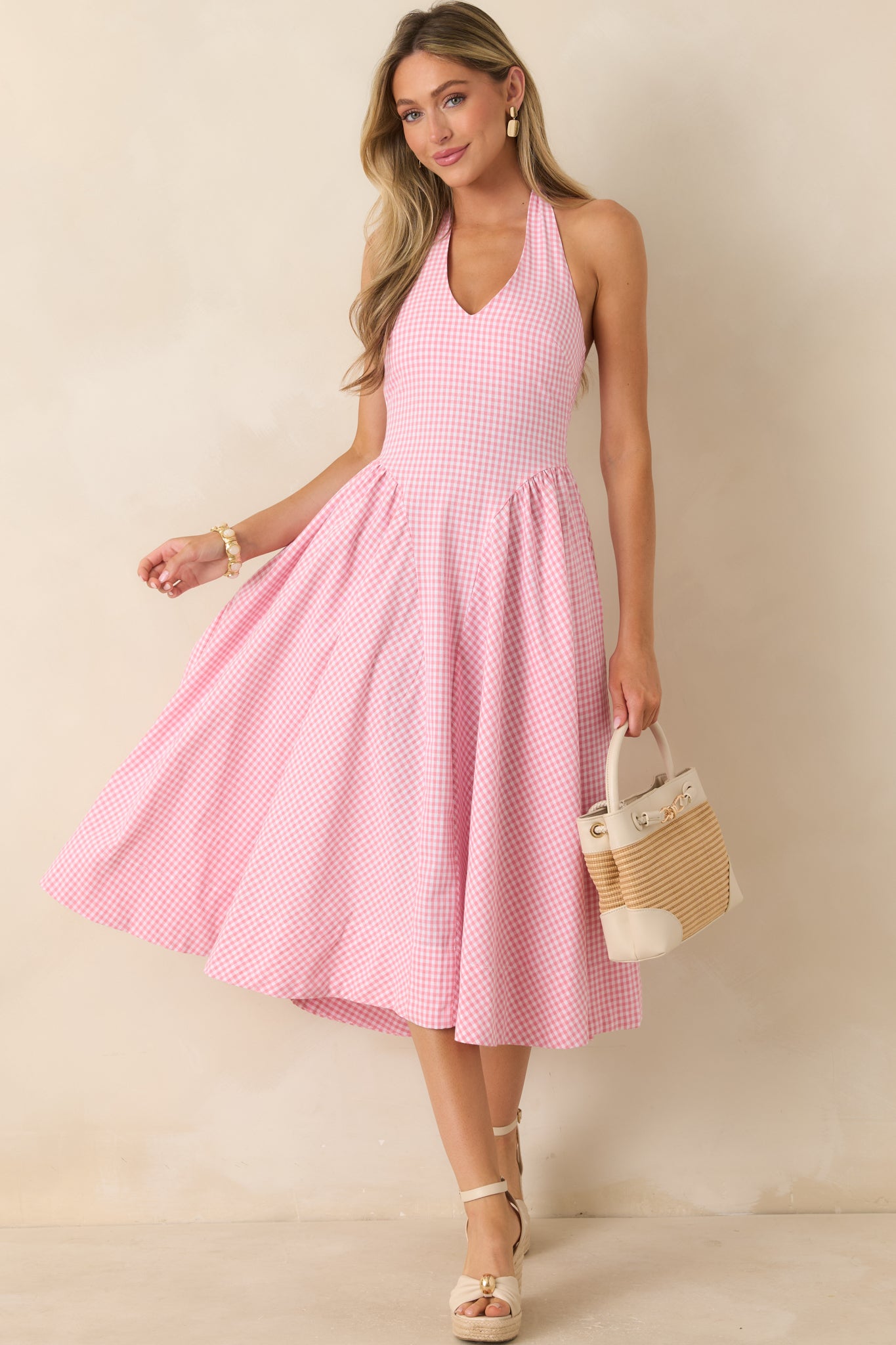 Pink cotton gingham midi dress featuring a halter neckline, fitted bodice, and full gathered skirt in lightweight woven fabric.