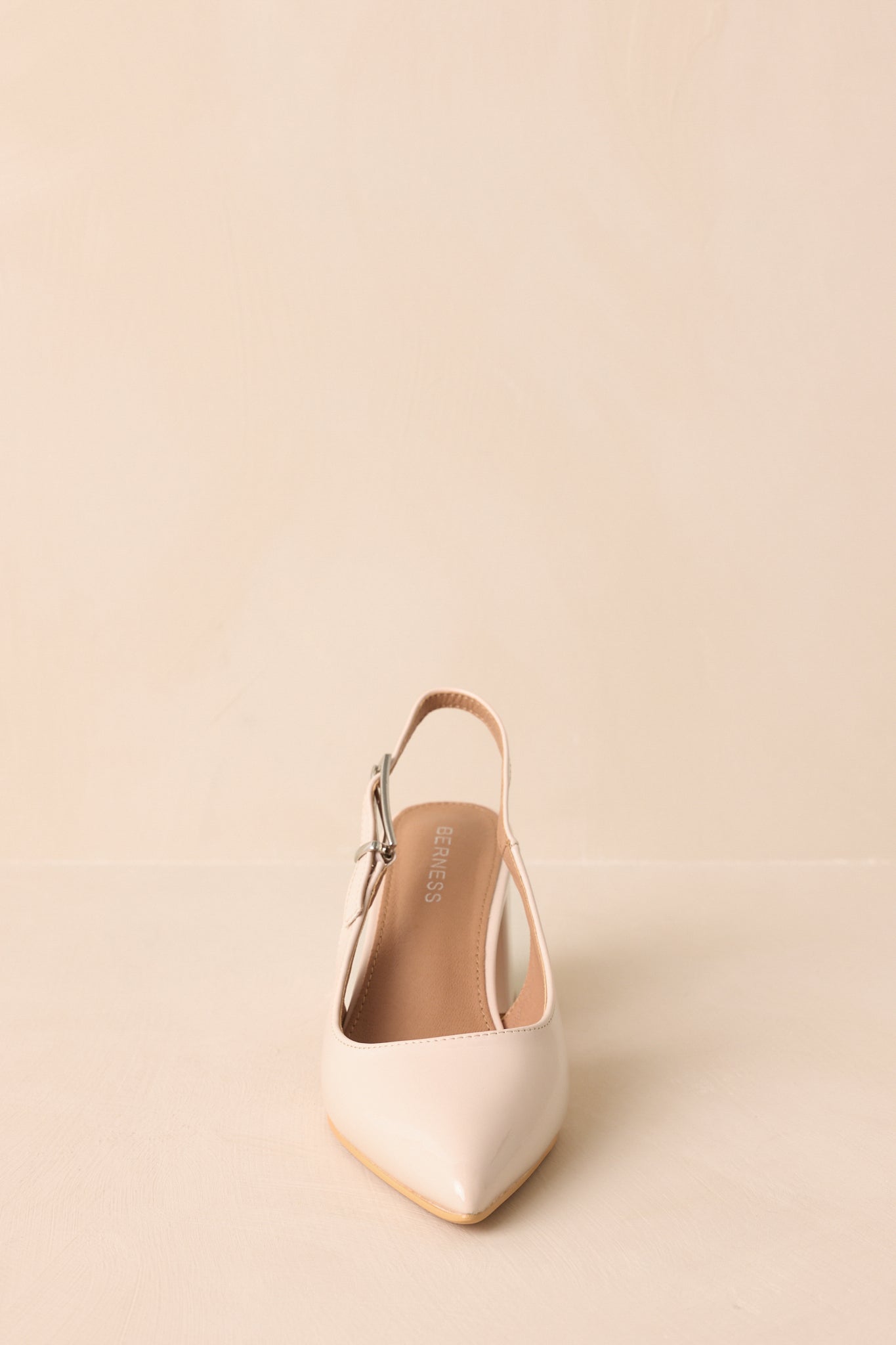 Front view emphasizing pointed toe and shiny patent finish.