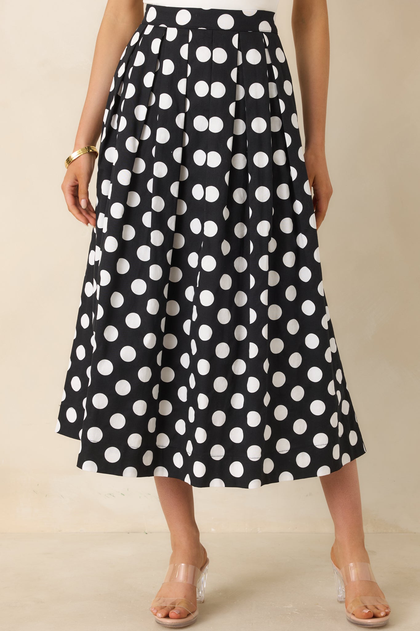 Close cropped angle highlighting black and white polka dot print and soft pleats.
