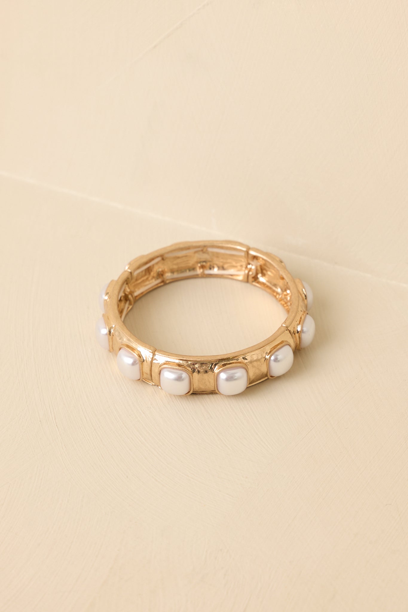 Detailed close-up of the bracelet focusing on the square pearl cabochons and polished gold-tone metal setting.