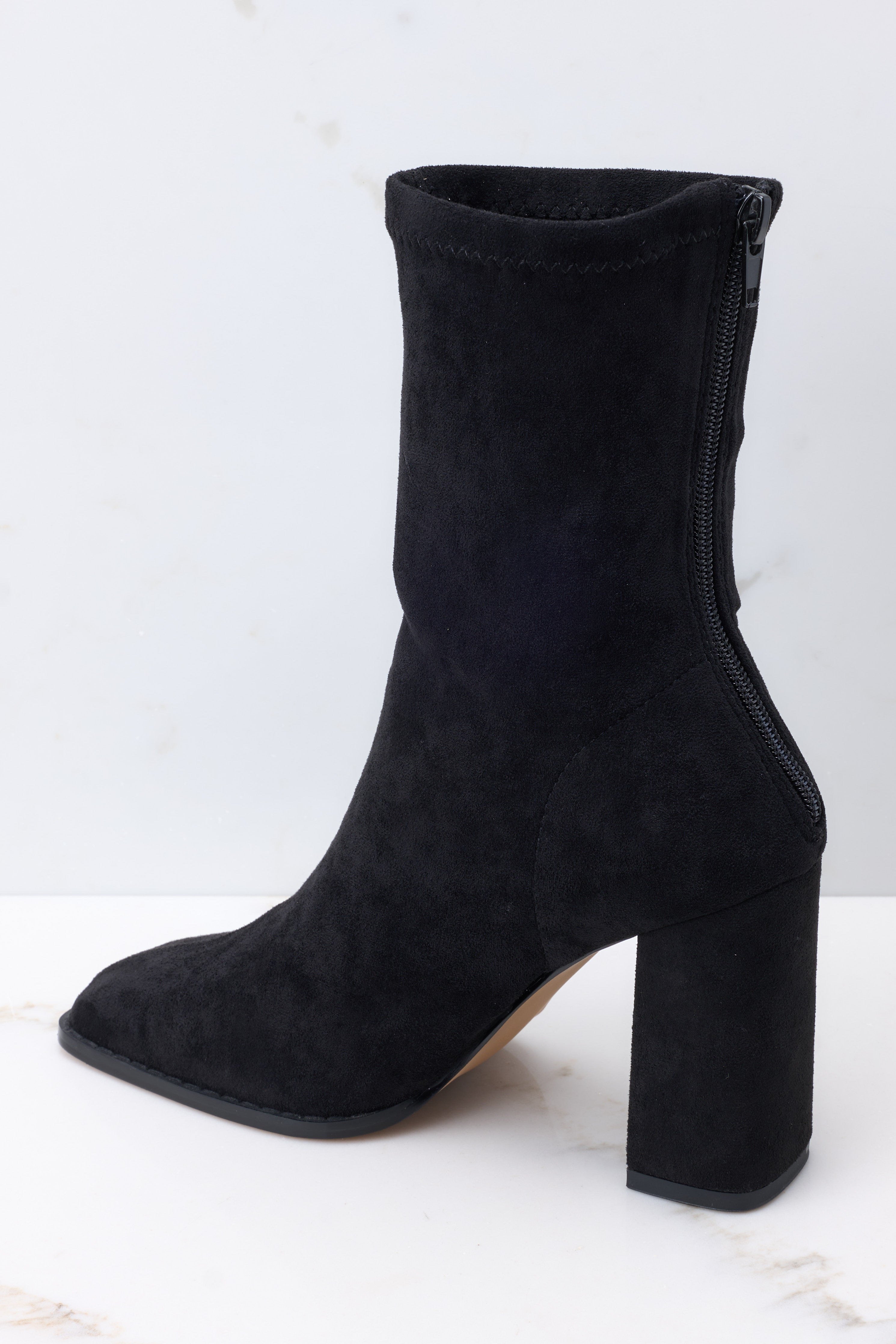 Inside view of black booties with a functional zipper down the back, and